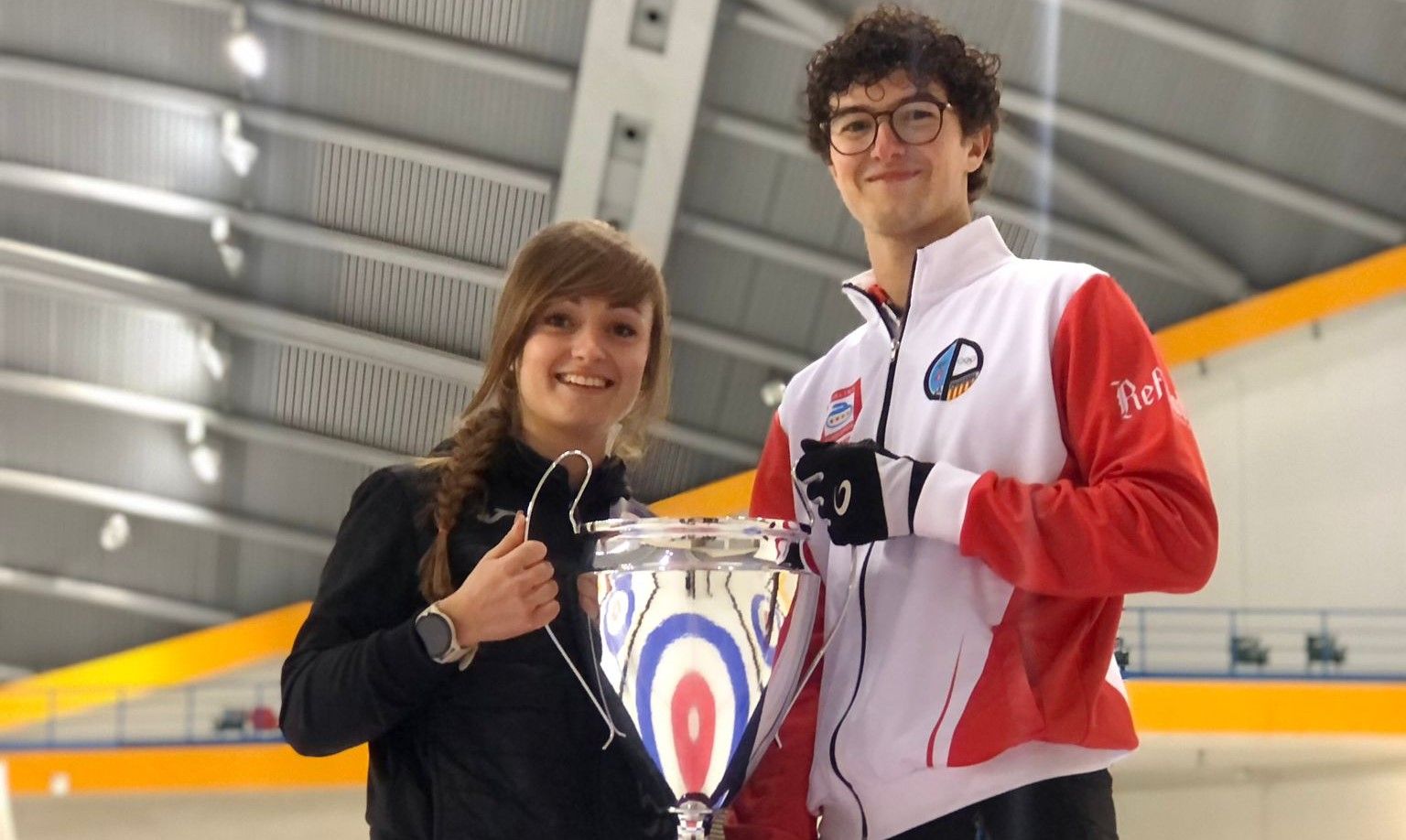 Carmen Pérez sonríe mientras sujeta el trofeo de campeona junto con Oriol Gastó