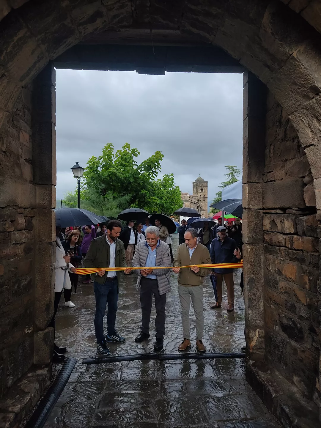 El homenajeado José Manuel Broto corta la cinta junto al alcalde Enrique Pueyo y el concejal Nicolás Baena