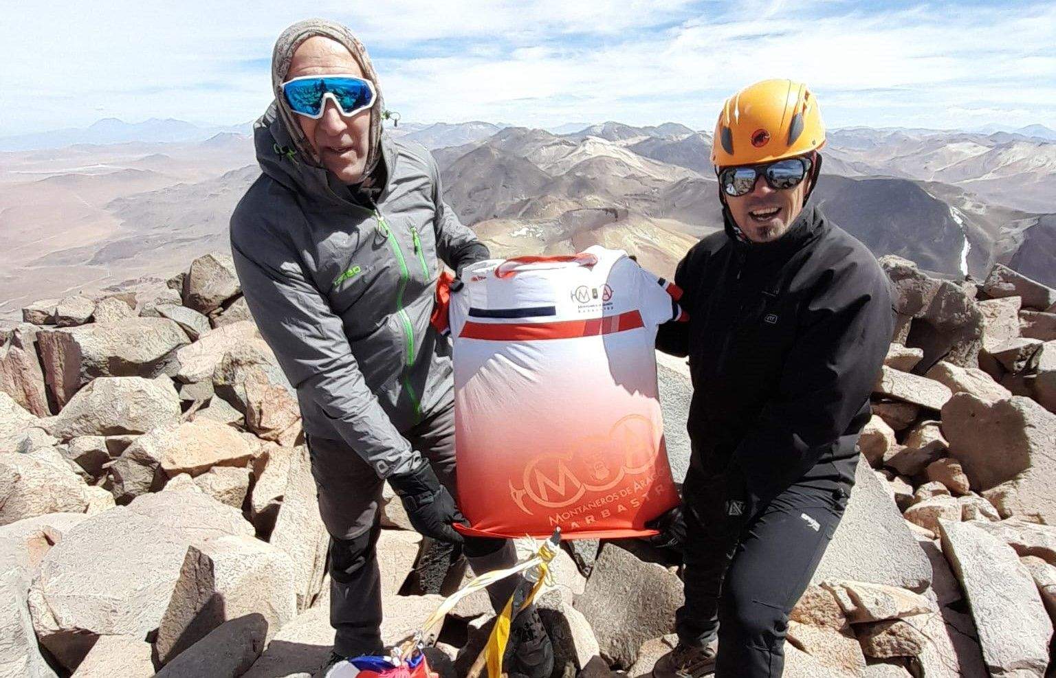 Ernesto Ester y Fernando Latorre posan con la camiseta de Montañeros de Aragón Barbastro en la cima del volcán. 