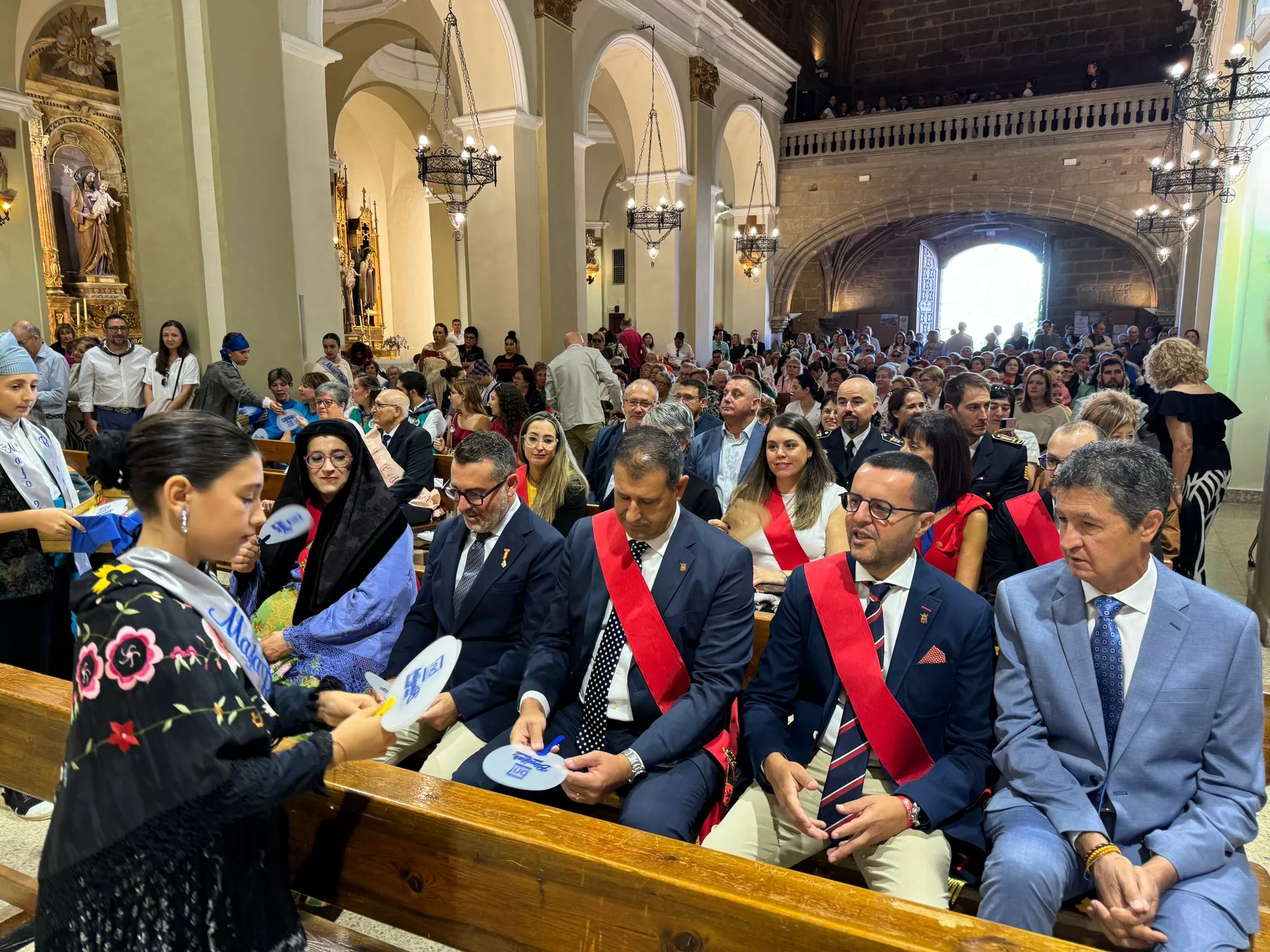 Celebración del día grande de las fiestas de Binéfar con la ofrenda de flores y el paloteau.