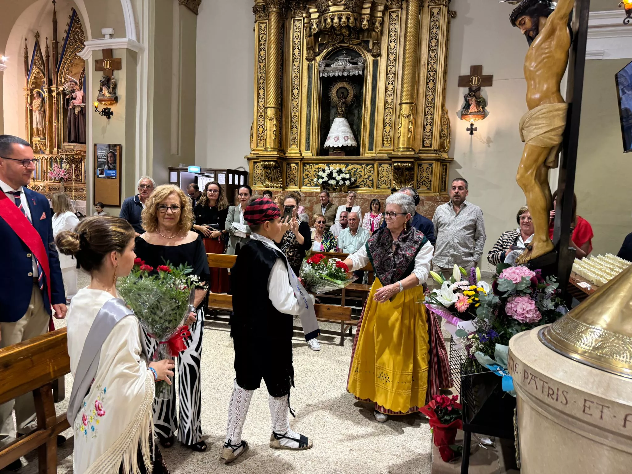 Celebración del día grande de las fiestas de Binéfar con la ofrenda de flores y el paloteau.