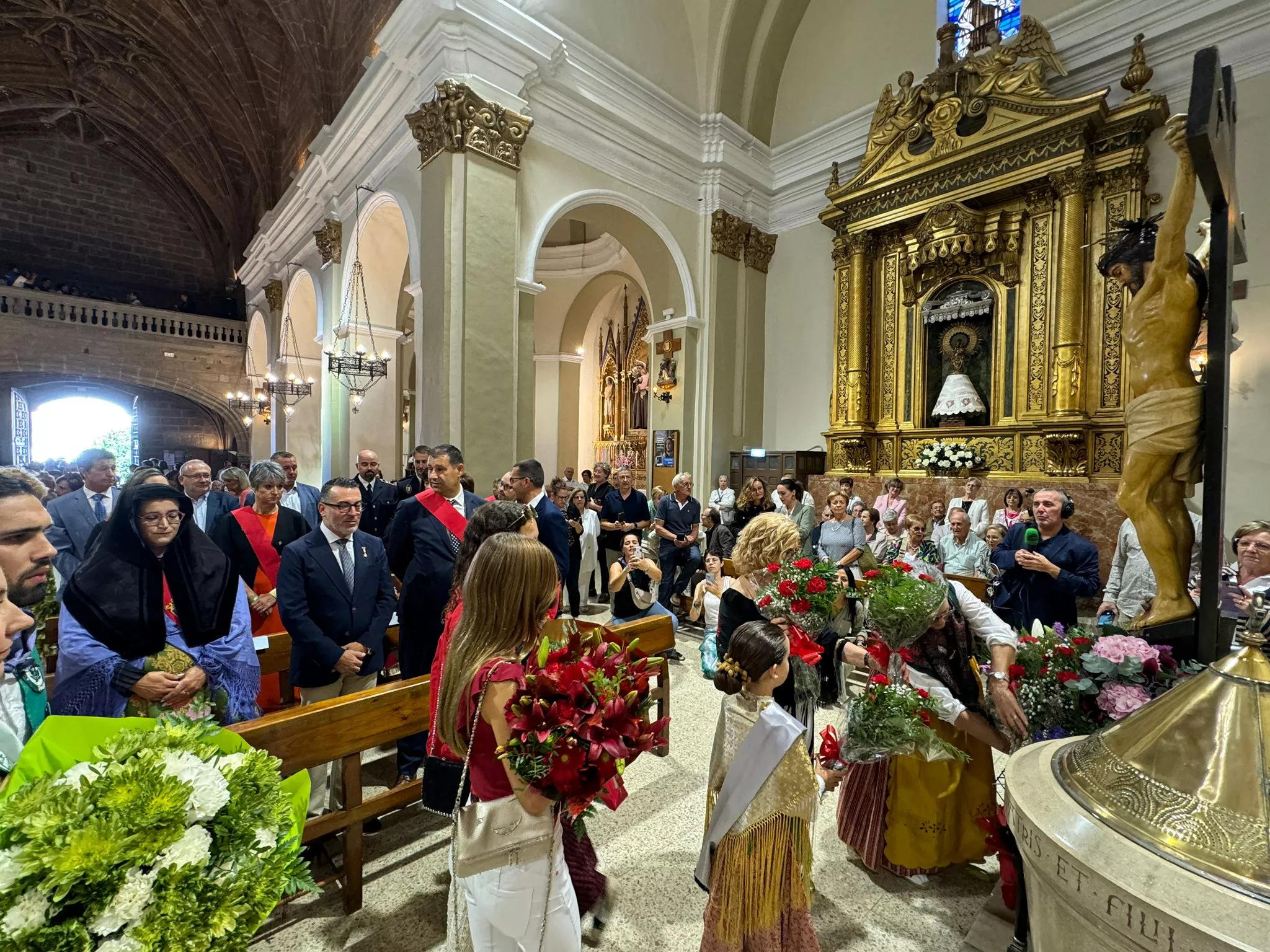 Celebración del día grande de las fiestas de Binéfar con la ofrenda de flores y el paloteau.