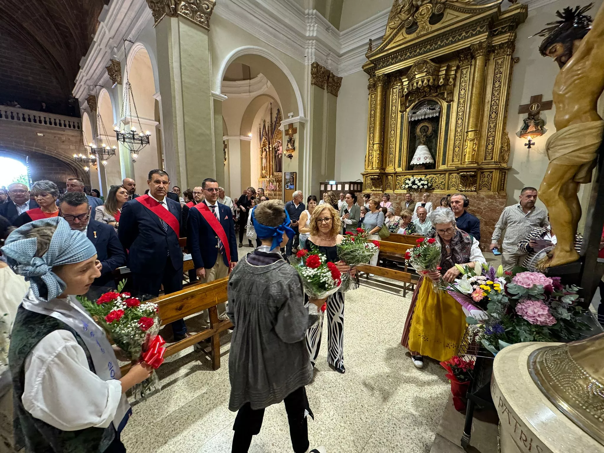 Celebración del día grande de las fiestas de Binéfar con la ofrenda de flores y el paloteau.