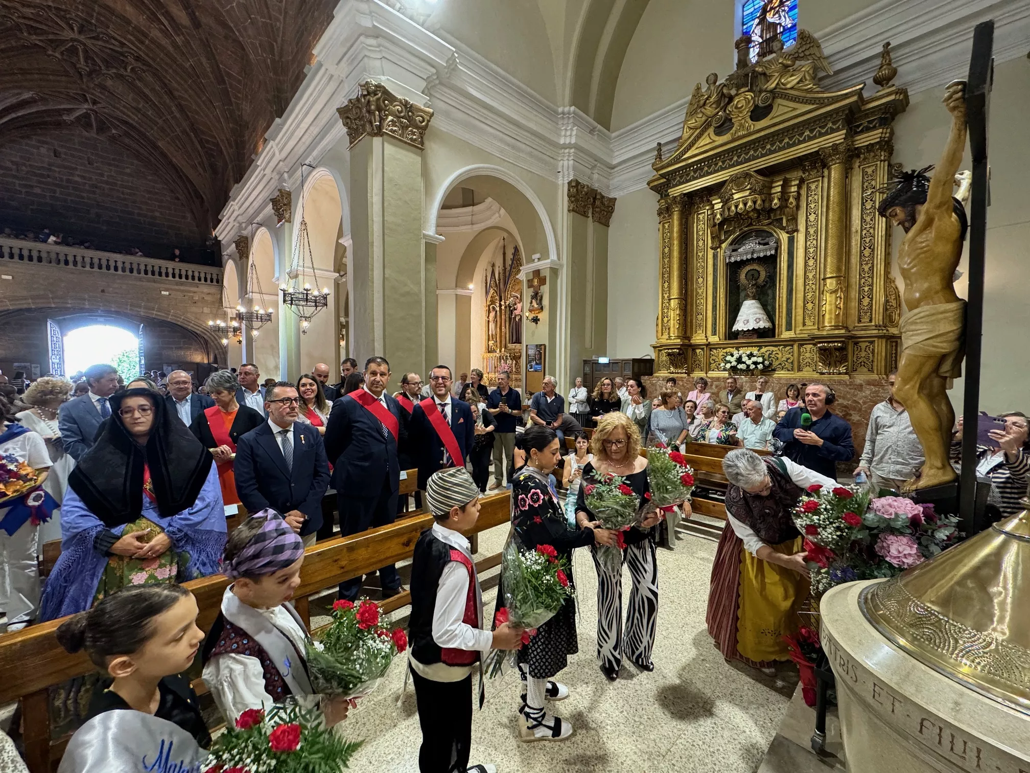 Celebración del día grande de las fiestas de Binéfar con la ofrenda de flores y el paloteau.