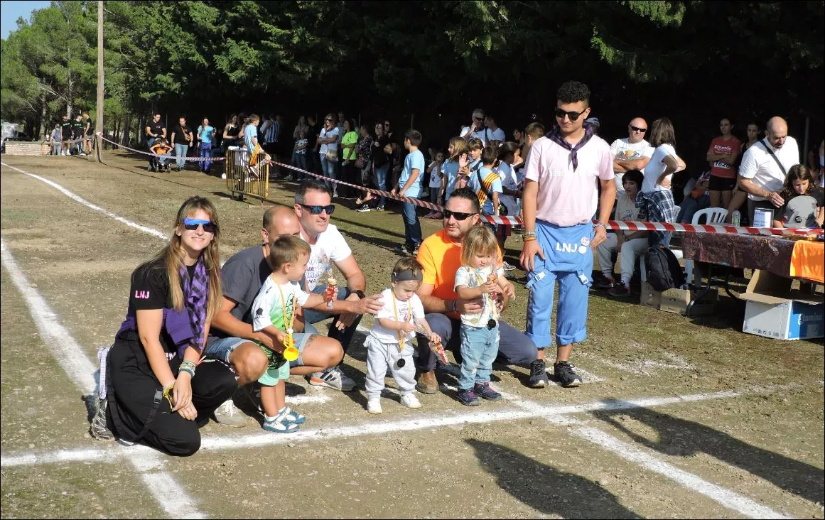 Niños hasta 3 años recibiendo medallas y chuches por miembros de la Comisión de Fiestas