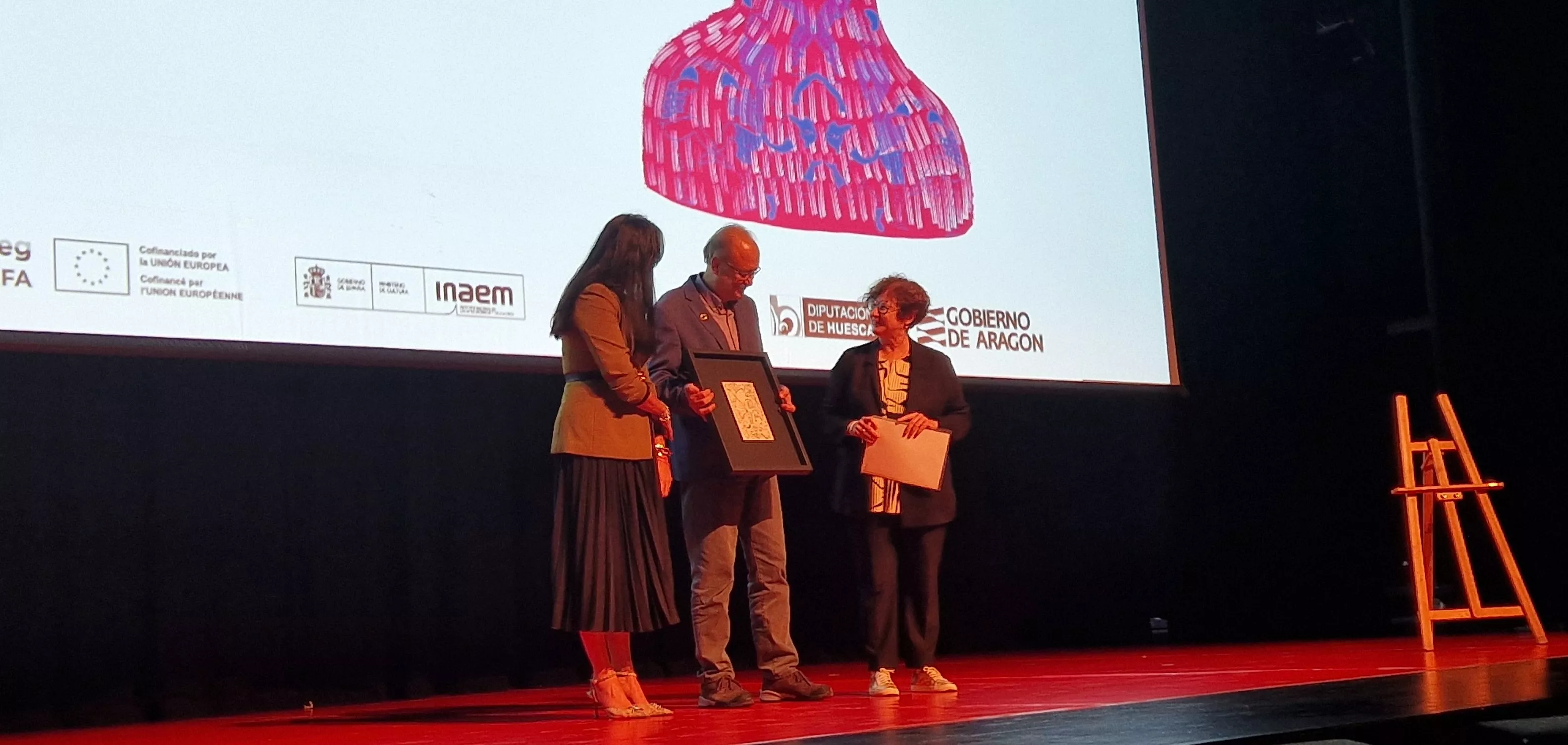 Alfons Martinell, entre la alcaldesa, Lorena Orduna, y Begoña Puértolas. Foto Myriam Martínez  2