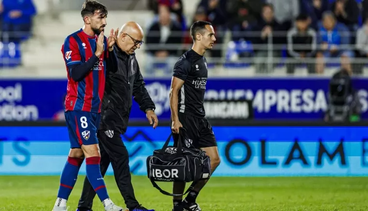 Javi Pérez se retira del terreno de juego acompañado por el doctor Galindo. Foto: SD Huesca