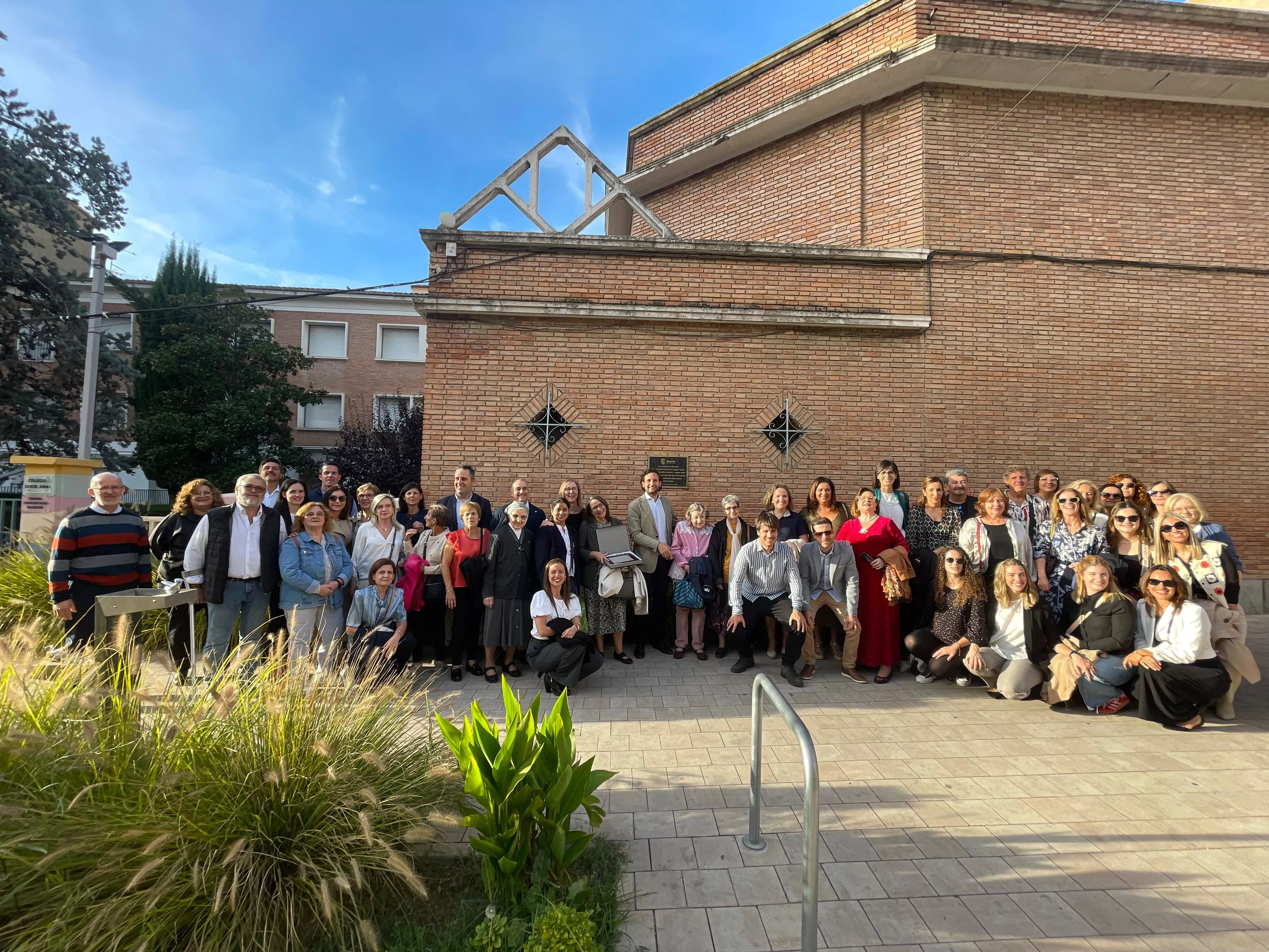 Foto de familia de las Hermanas de Santa Ana y los representantes municipales en la fachada del Colegio