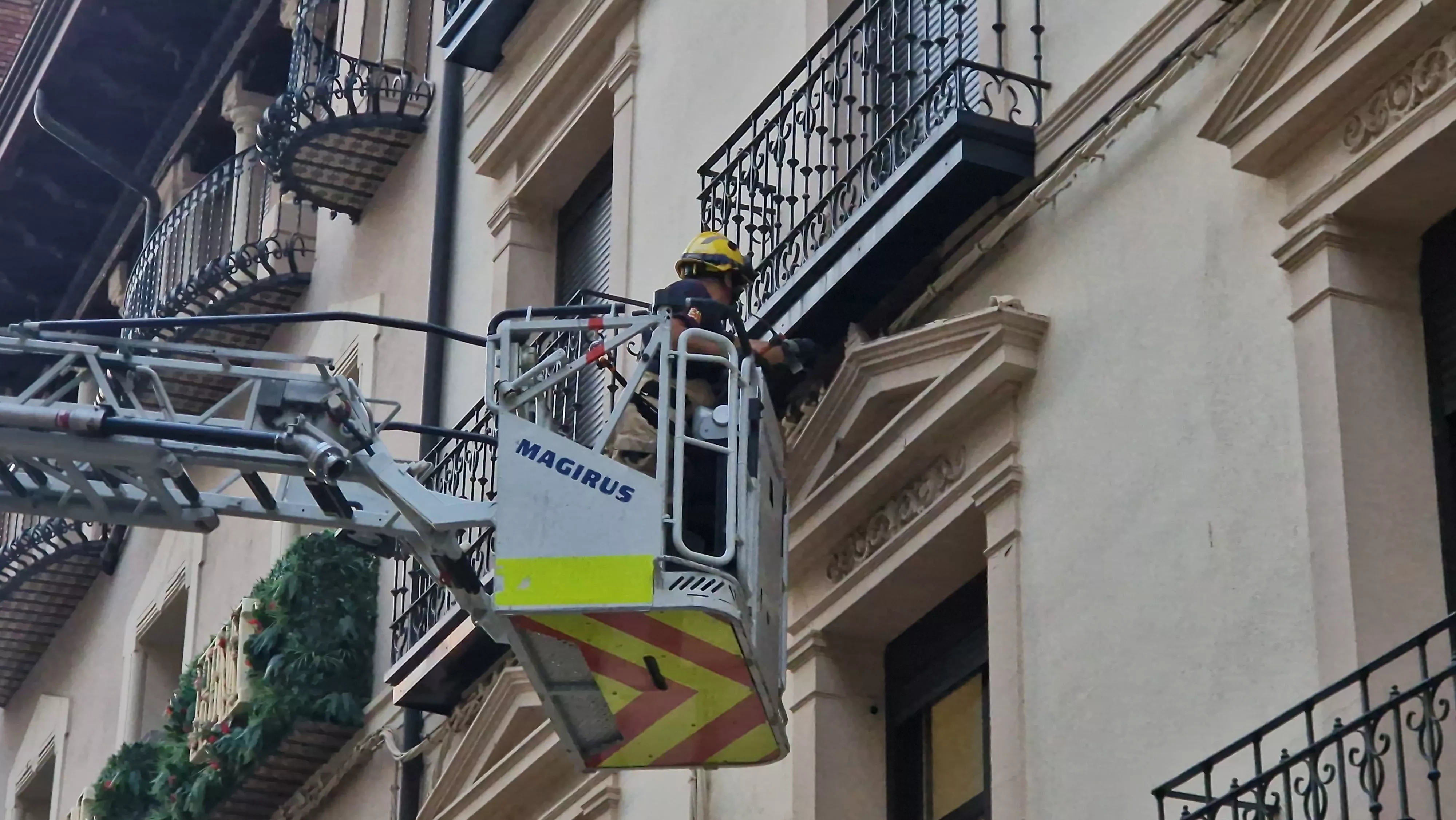 Los Bomberos de Huesca, interviniendo en la fachada del edificio del Coso Bajo. Foto Myriam Martínez