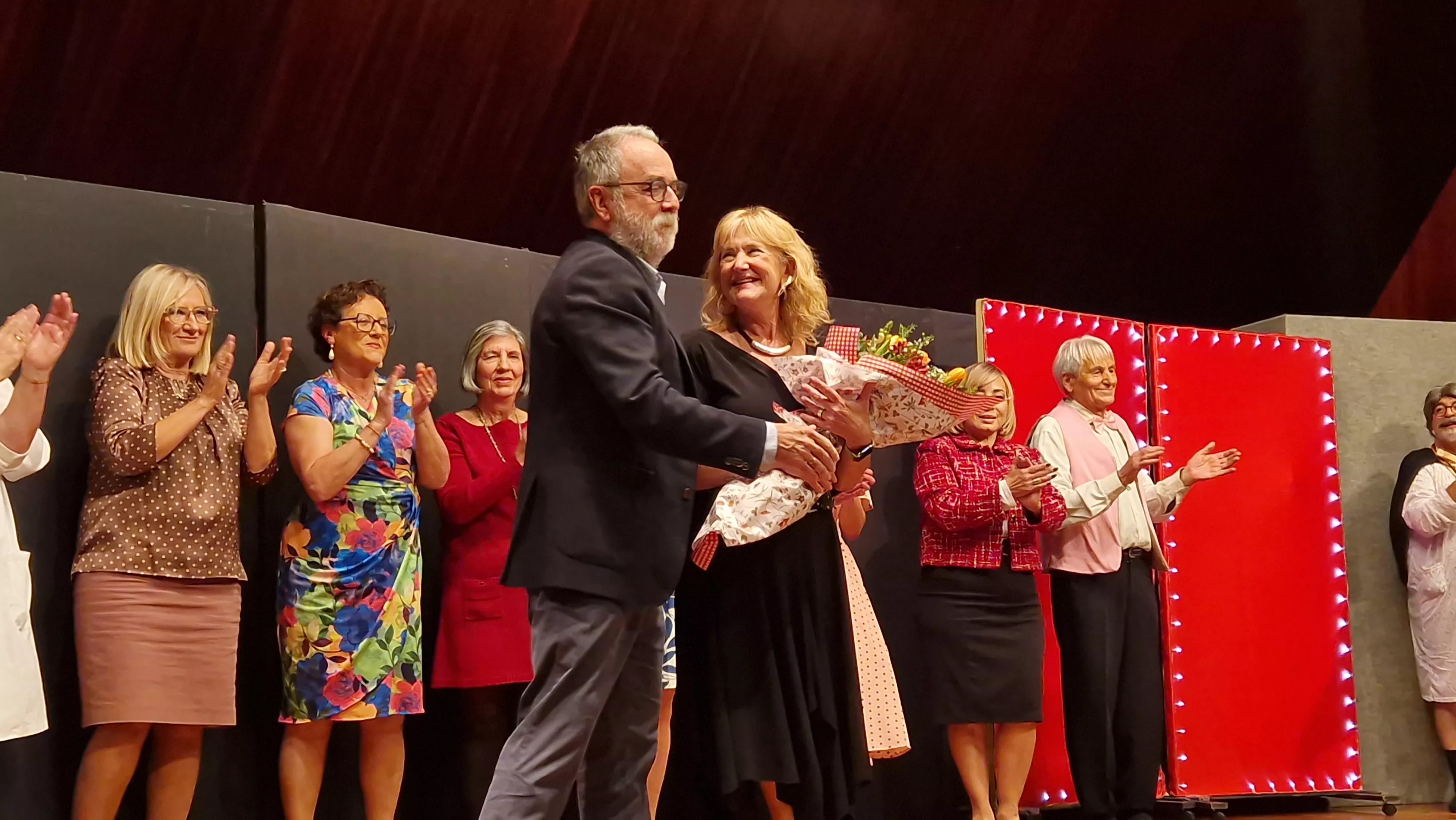 El presidente de la AECC en Huesca, José Manuel Ramón y Cajal, entrega un ramo de flores a Carmen Sierra. Foto Myriam Martínez