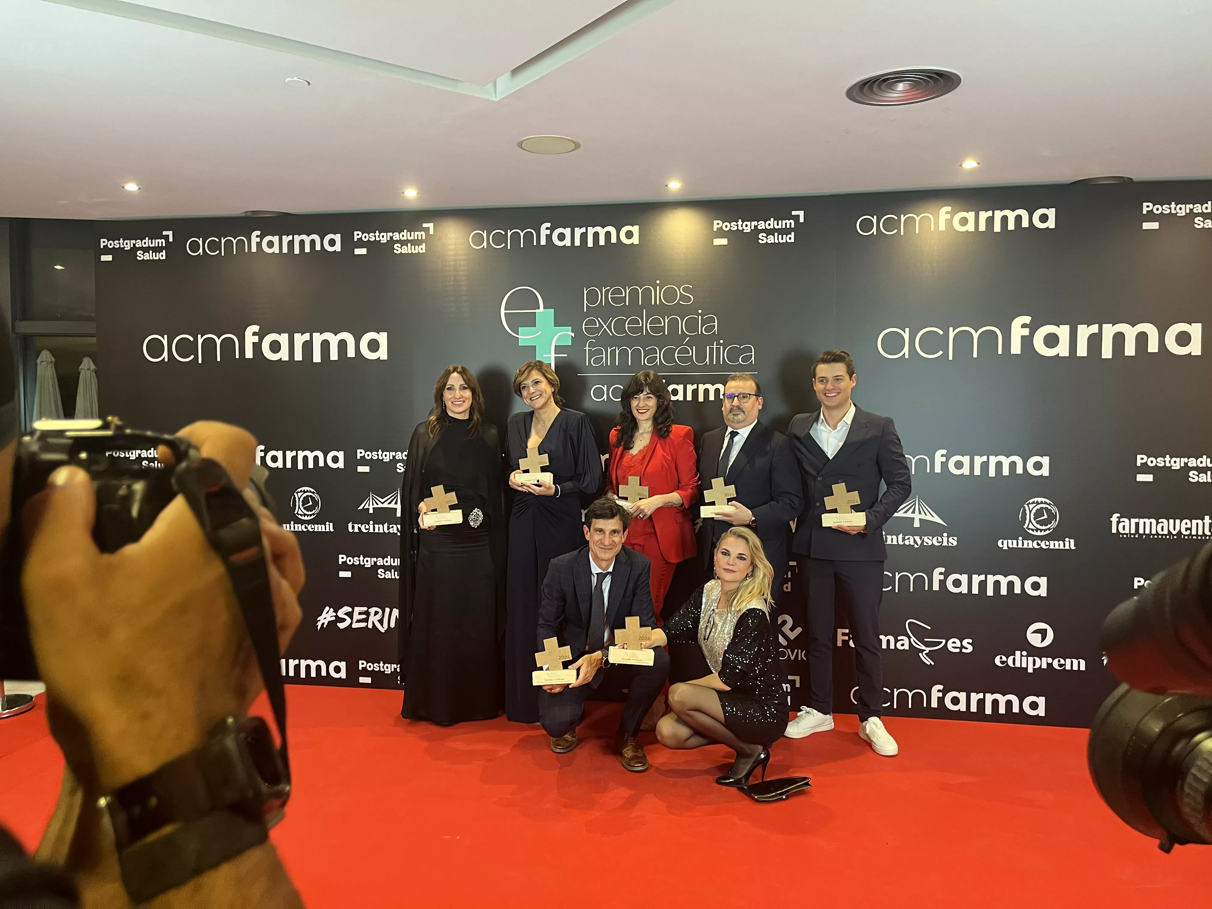 Diego Marro, agachado, con el Premio a Farmacia Destacada de España