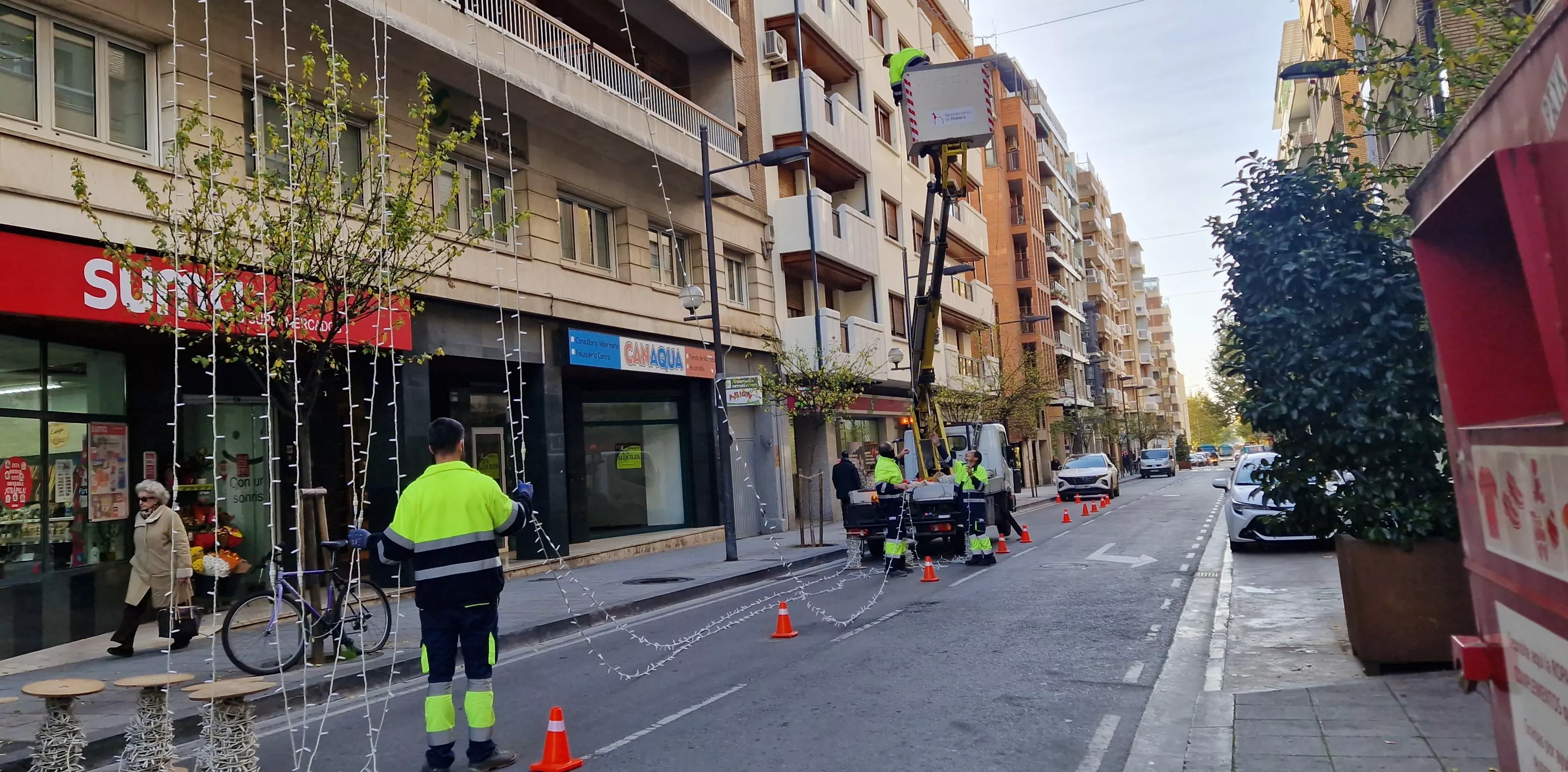 Los operarios, trabajando en la calle Zaragoza para colocar la iluminación navideña. Foto Myriam Martínez