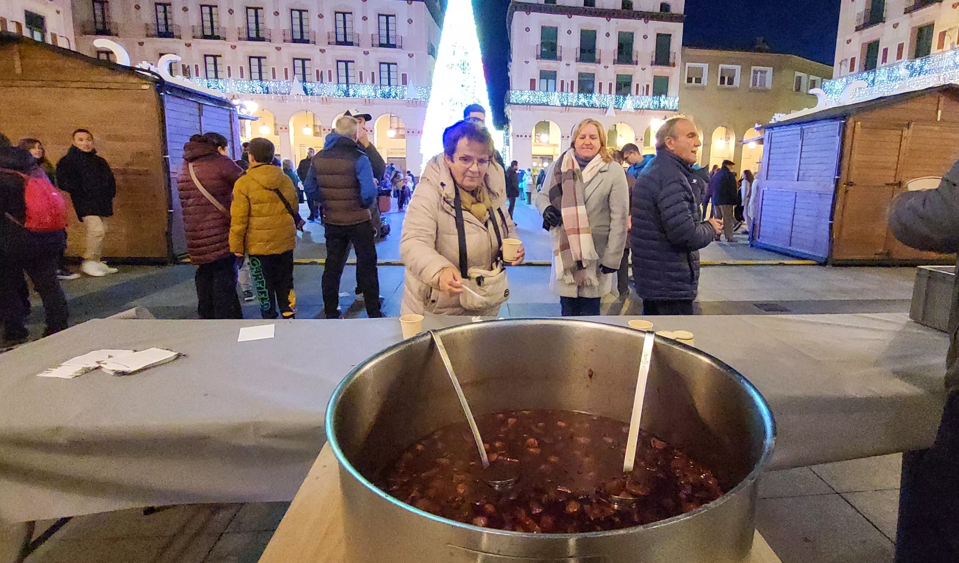 Reparto de poncho en el Mercado Local de Navidad de Huesca.