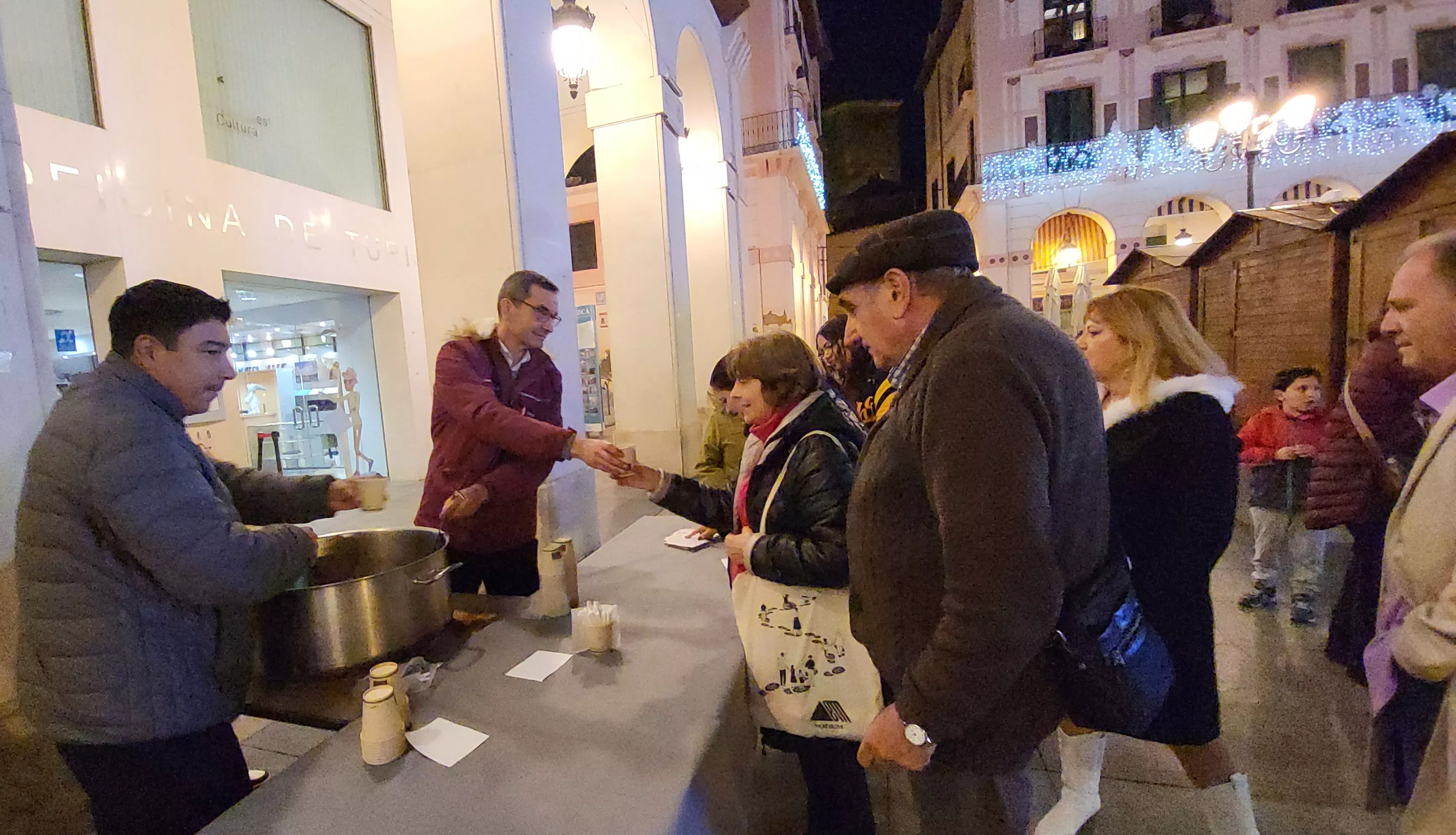 Reparto de poncho en el Mercado Local de Navidad de Huesca.