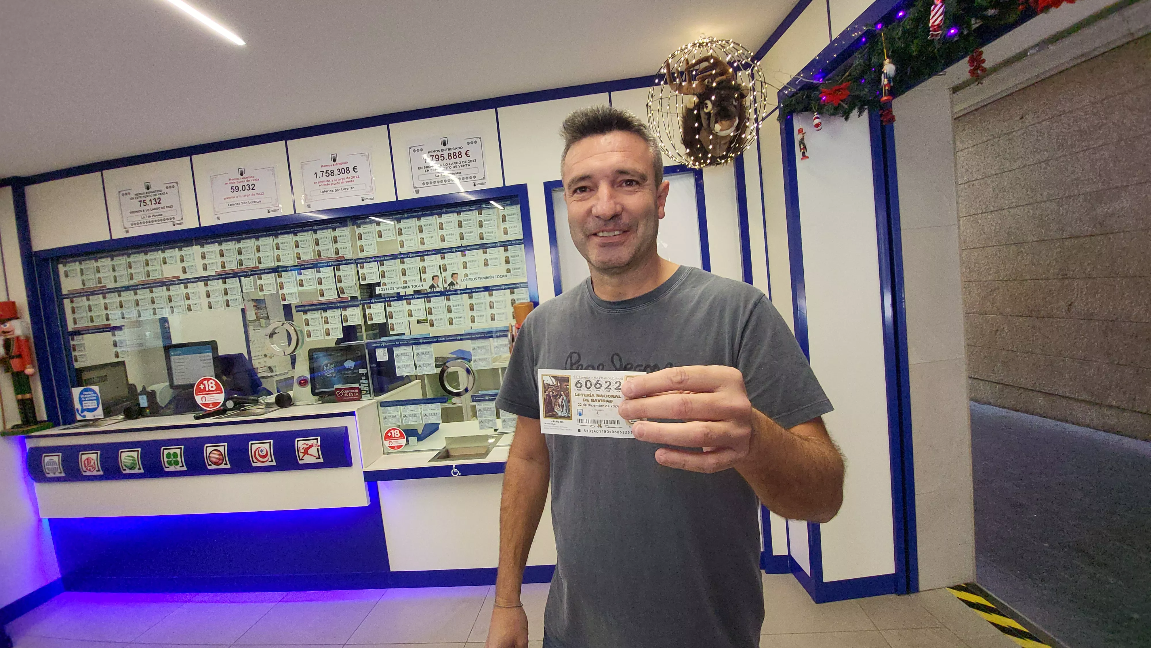 Fernando Alagón sostiene uno de los décimos agraciados con un quinto premio de la Lotería Nacional.