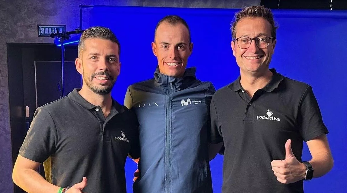 Enric Mas, ciclista de Movistar, en el centro, junto a Javier Alfaro, de Podoactiva.