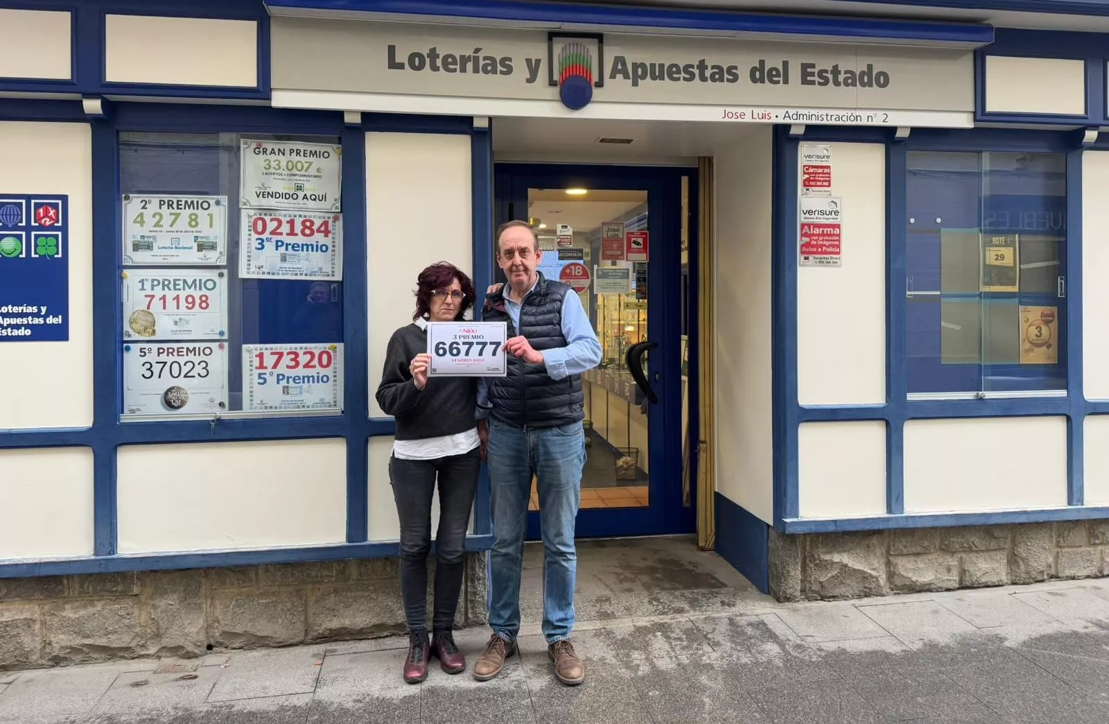 José Luis Dessy junto a su esposa con el número premiado en la puerta de su administración número 2 de Jaca.