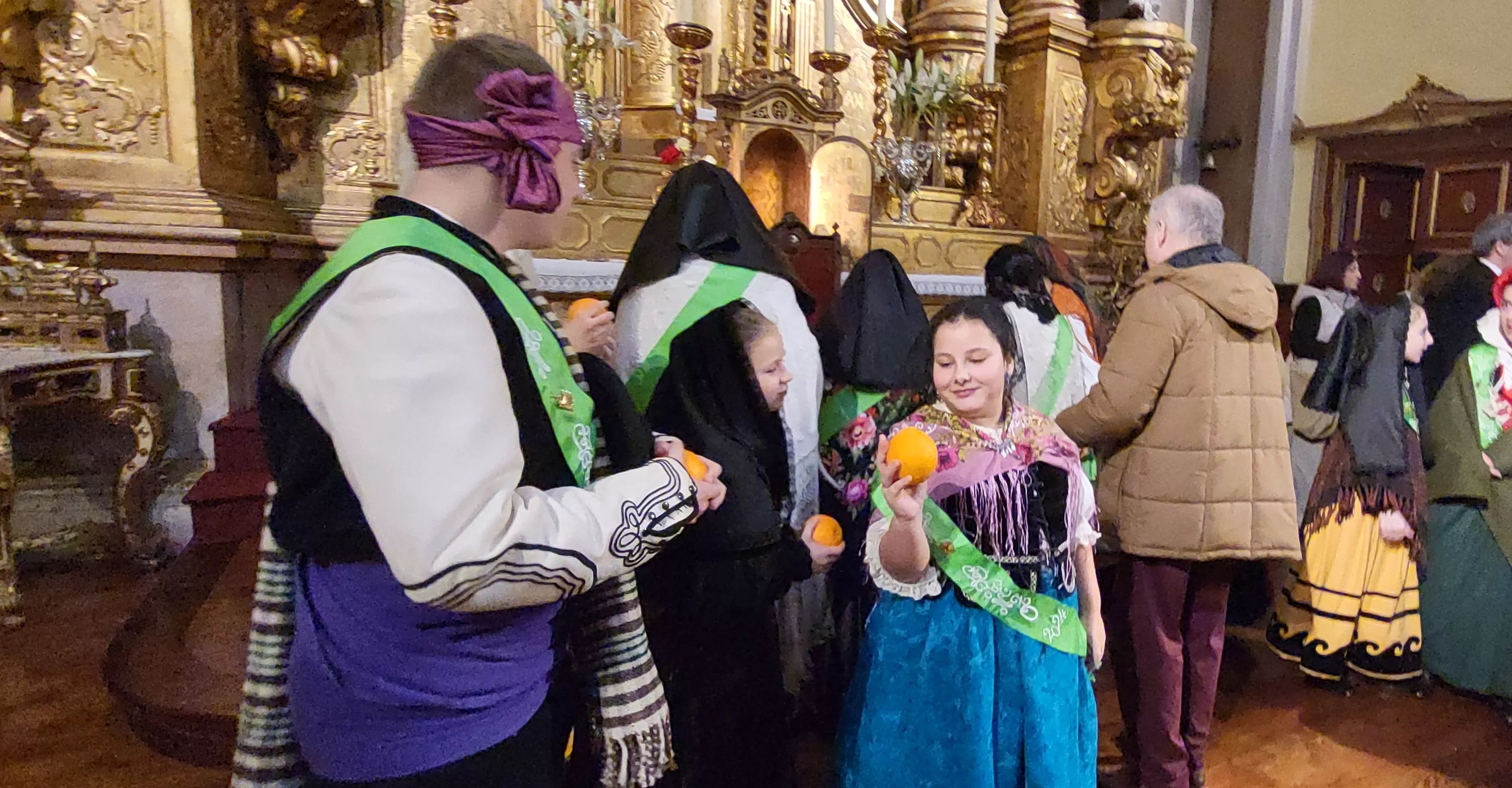 Tradicional reparto de naranjas al término de la misa. Foto Mercedes Manterola