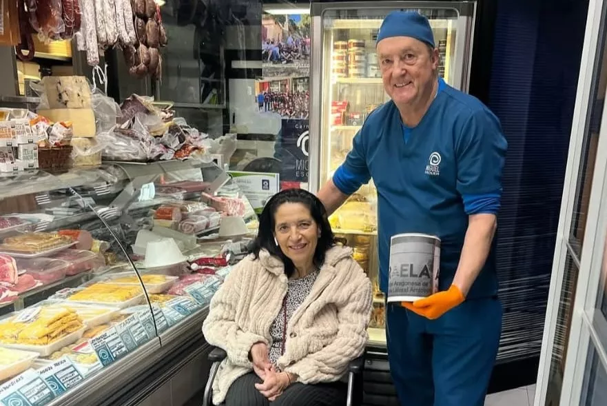 Belén Arcos y Miguel Escuer en la carnicería con las huchas por la ELA Belén Arcos y Miguel Escuer en la carnicería con las huchas por la ELA