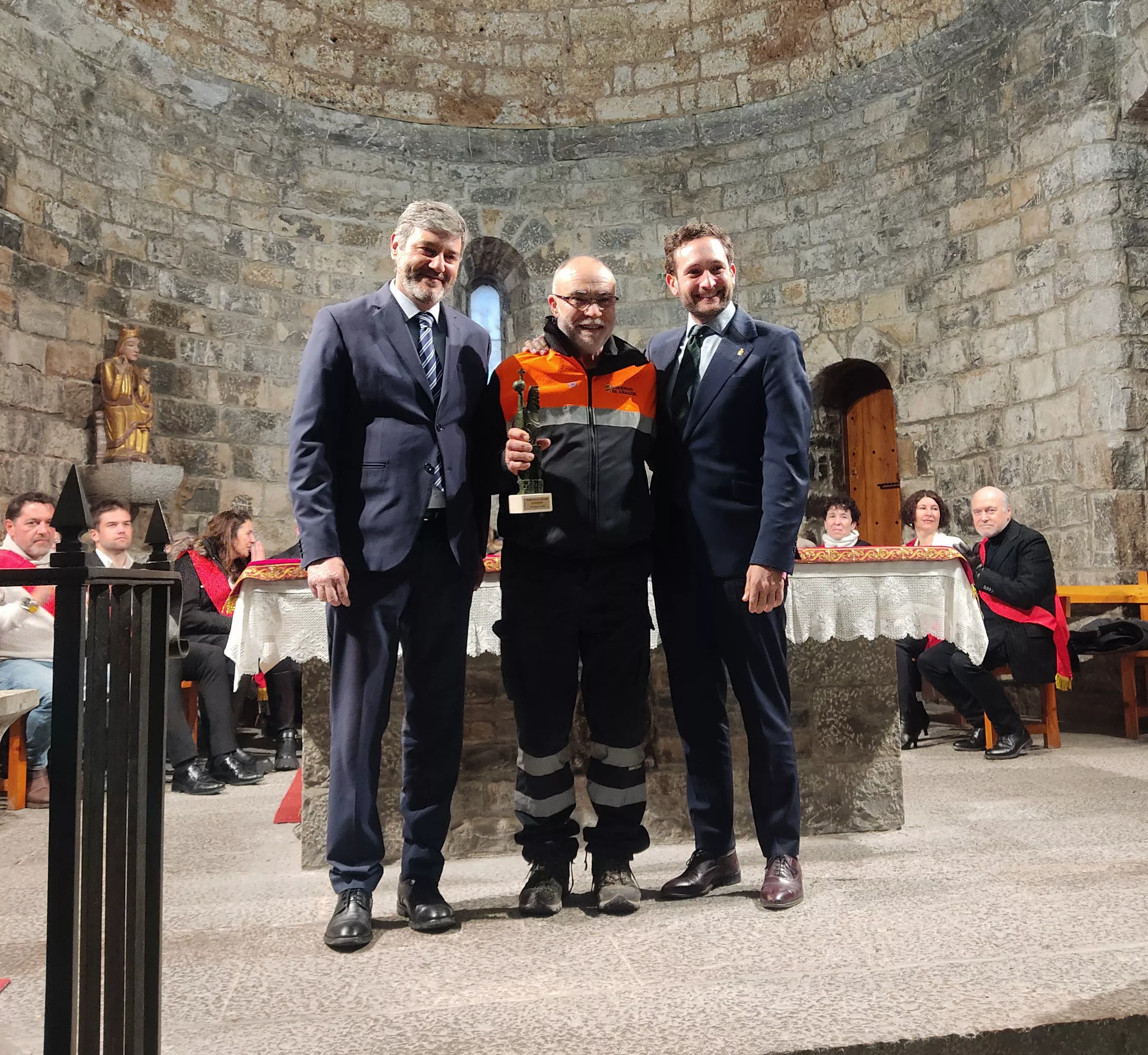 Luis Lanau, en nombre de la agrupación de voluntarios de protección civil, recoge el premio de manos de Isaac Claver y Gerardo Oliván