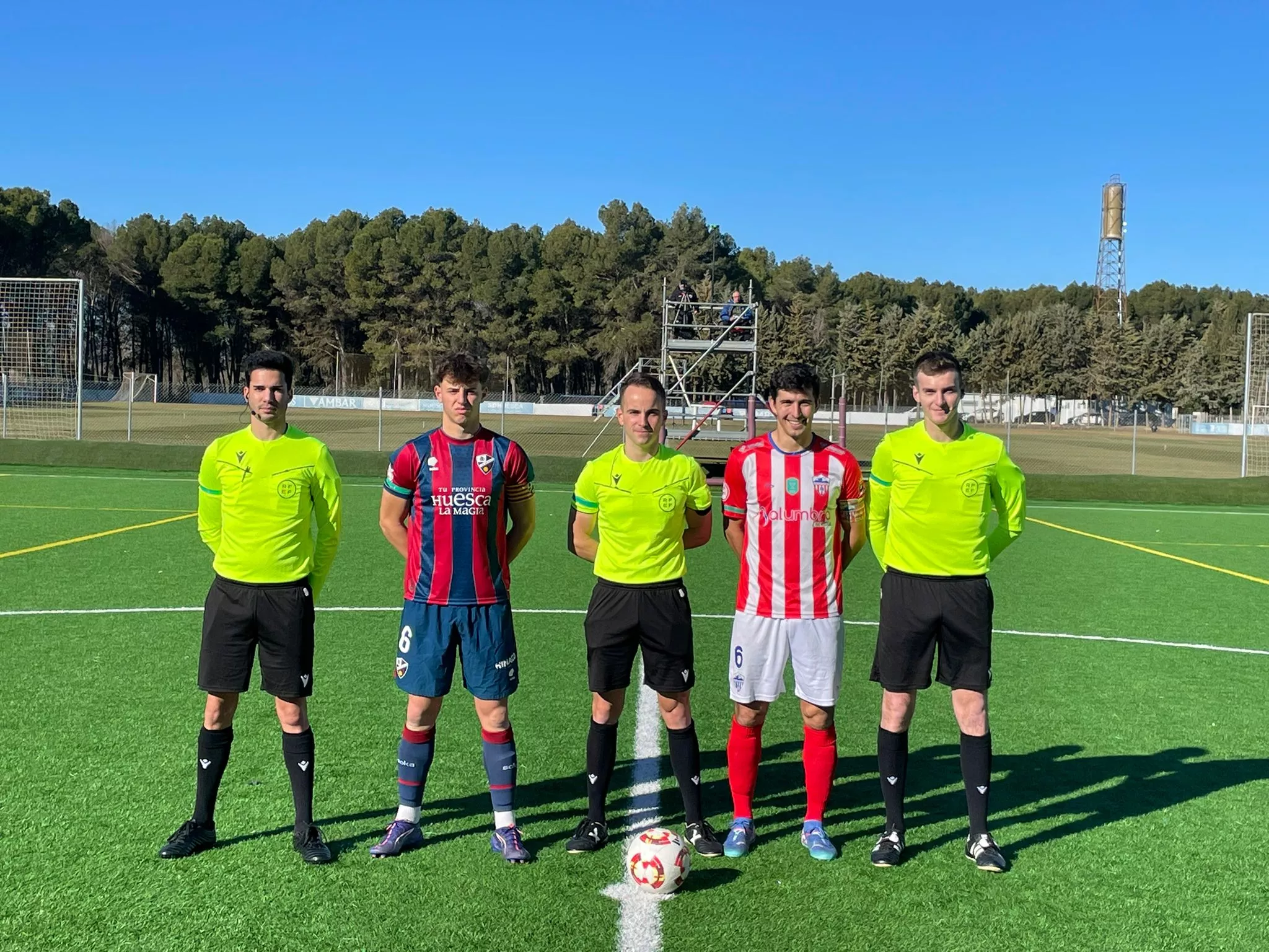 Foto inicial de los capitanes de Huesca B y Monzón con los árbitros.