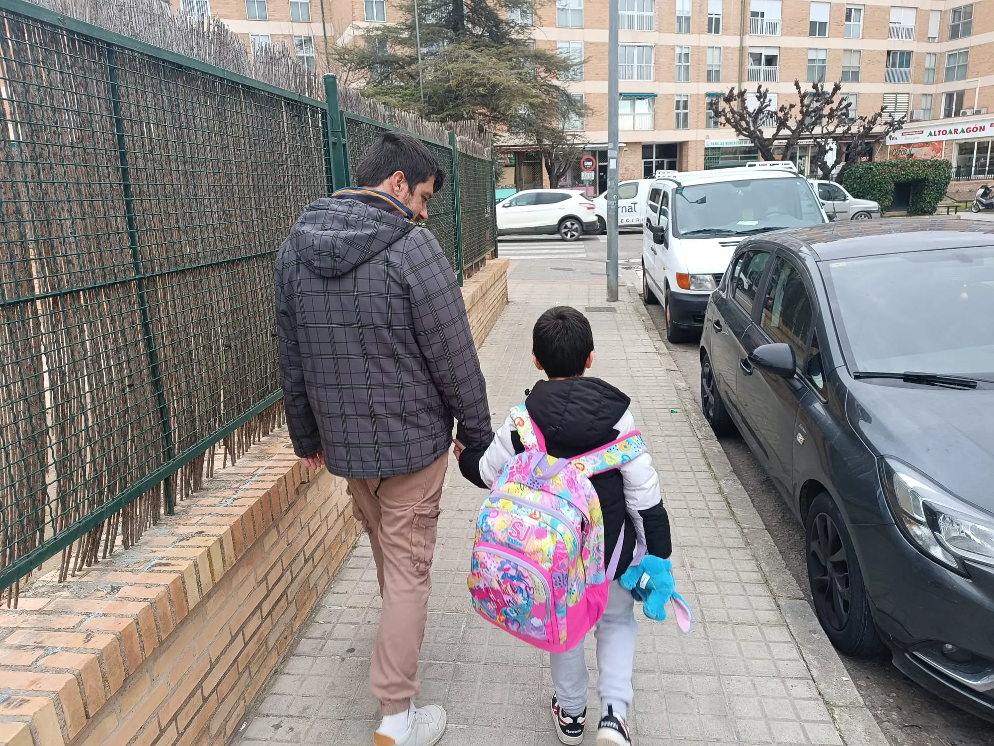 Juan, de camino al colegio, acompañado por su padre Raúl.