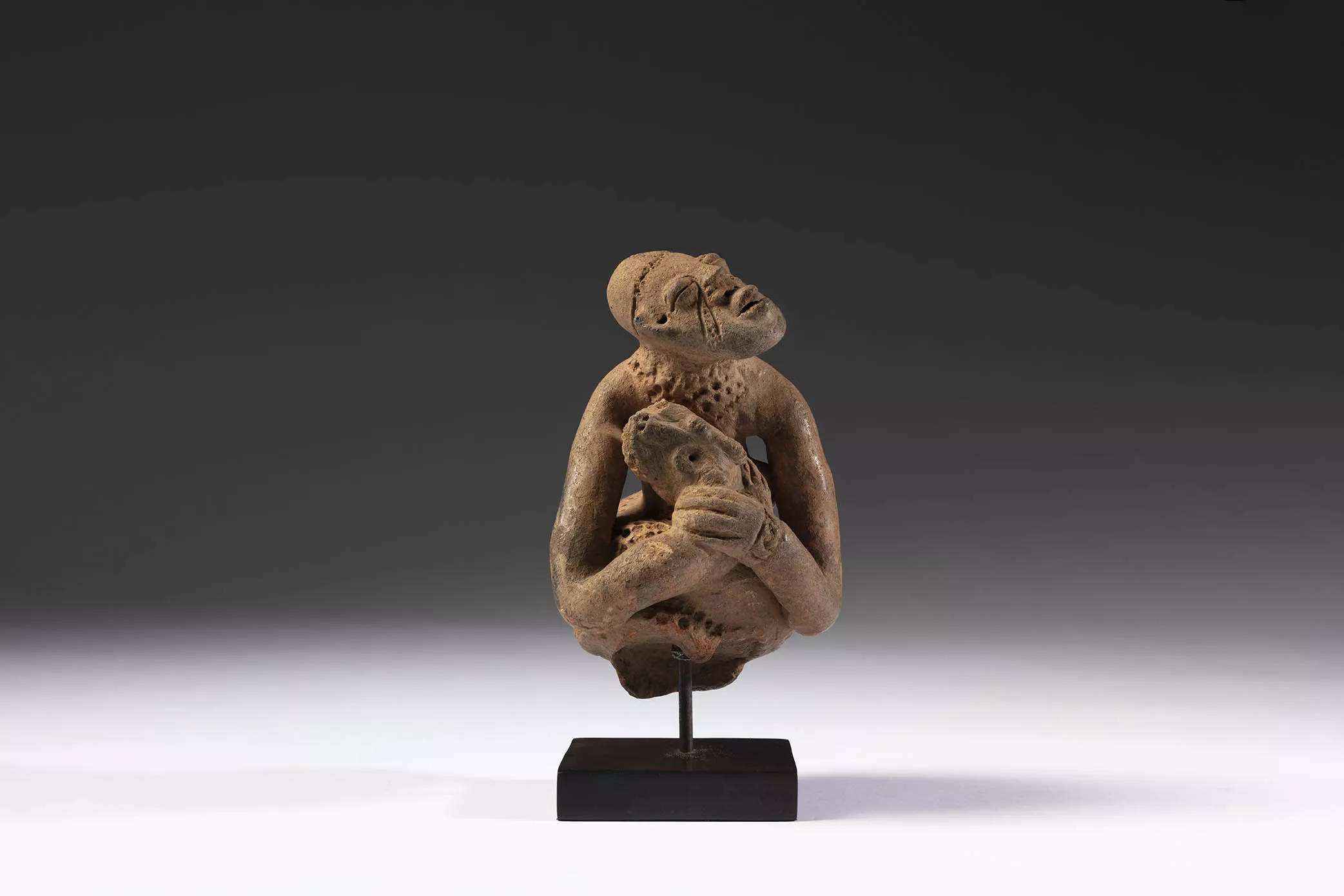 Representación de un personaje sosteniendo una serpiente. Cultura de Djenné. Mali. Siglos XII - XVI. Terracota, 20 x 12 x 12 cm.