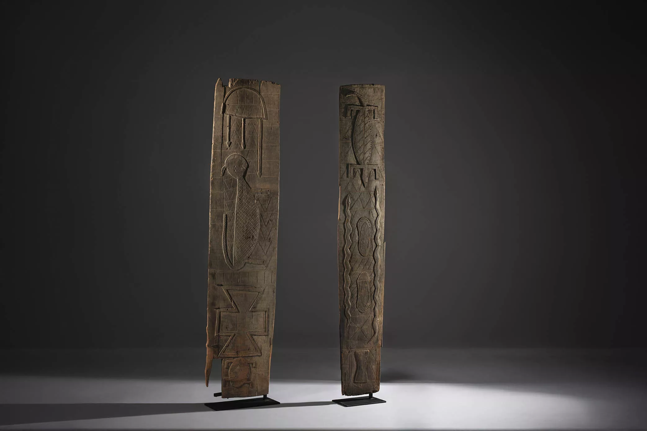 Dos paneles de una puerta de casa de alto rango. Cultura nupe. Nigeria. Finales del siglo XIX. Madera con fuerte pátina de oxidación,   208 x 48 x 1,5 cm / 208 x 34 x 1,5 cm.