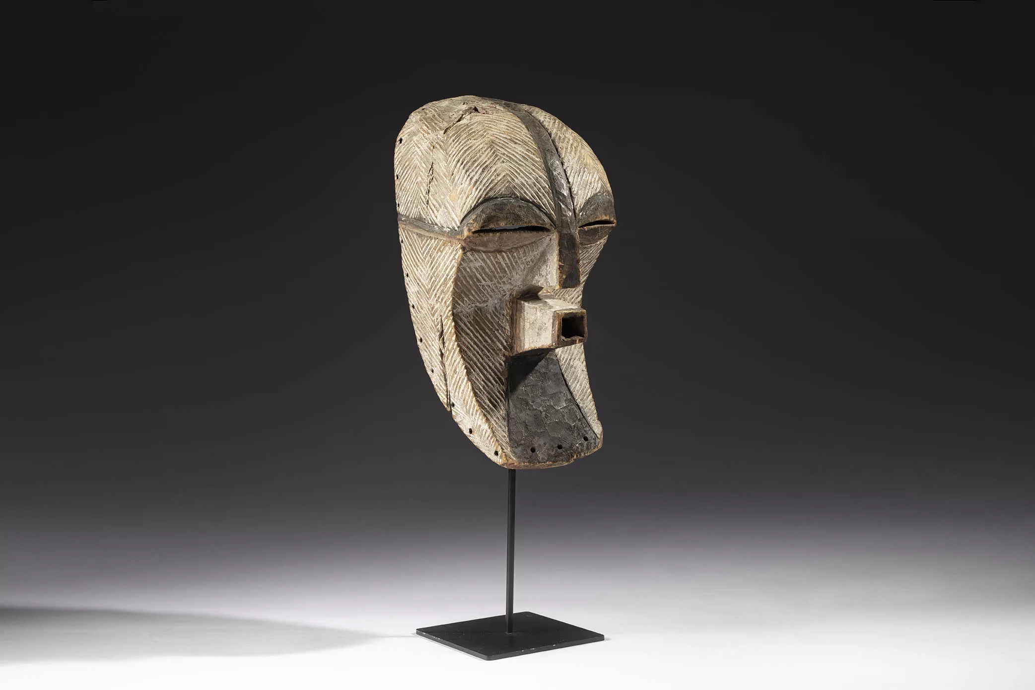 Máscara masculina del tipo kifwebe mostrando escarificaciones. Cultura songye. República Democrática del Congo. Primera mitad del siglo XX. Madera y pigmentos, 42 x 20 x 19 cm.