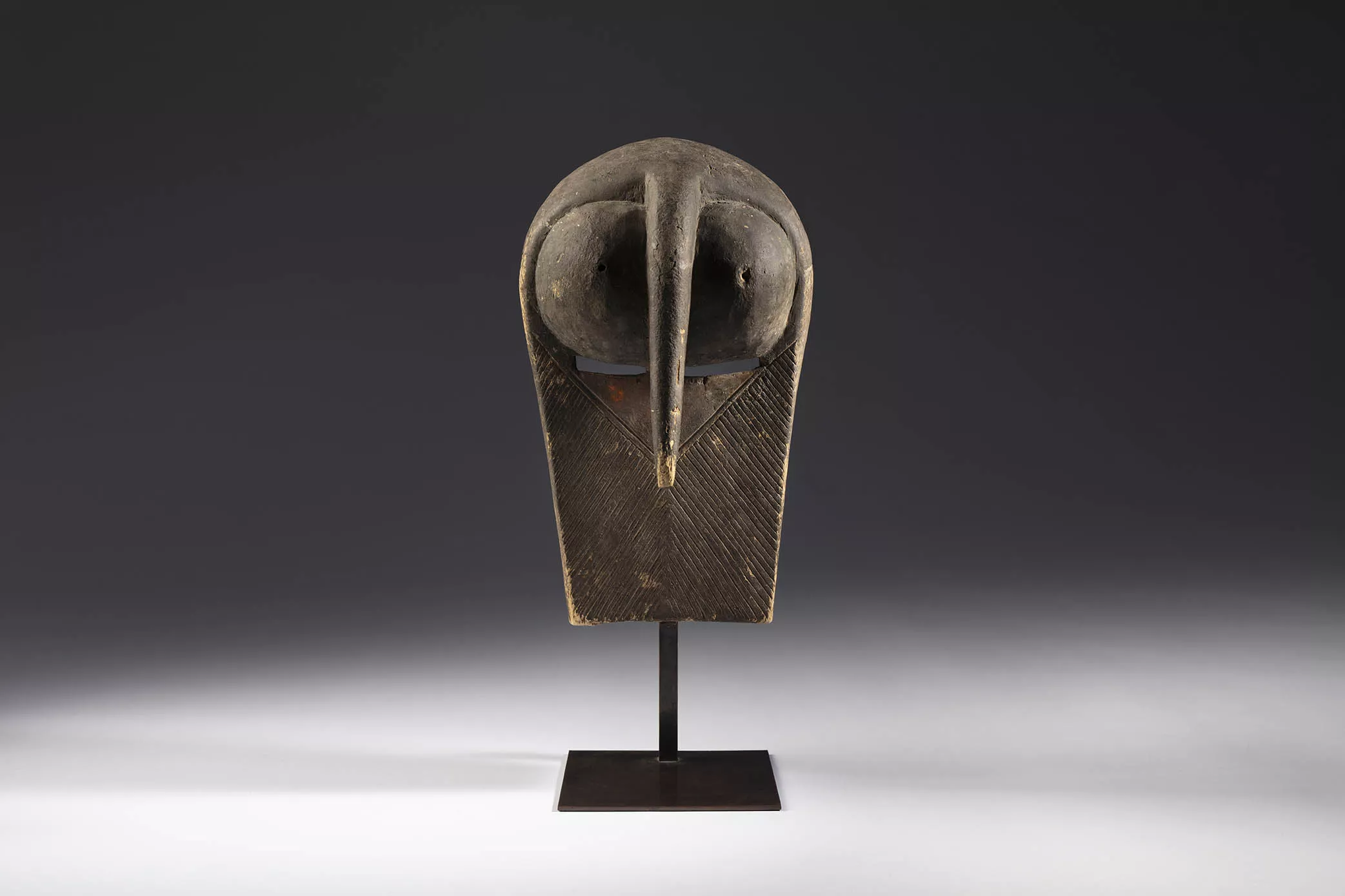 Máscara del tipo kifwebe representando un búho. Cultura songye o luba. República Democrática del Congo. Primera mitad del siglo XX. Madera y pigmentos, 33 x 19 x 16 cm.