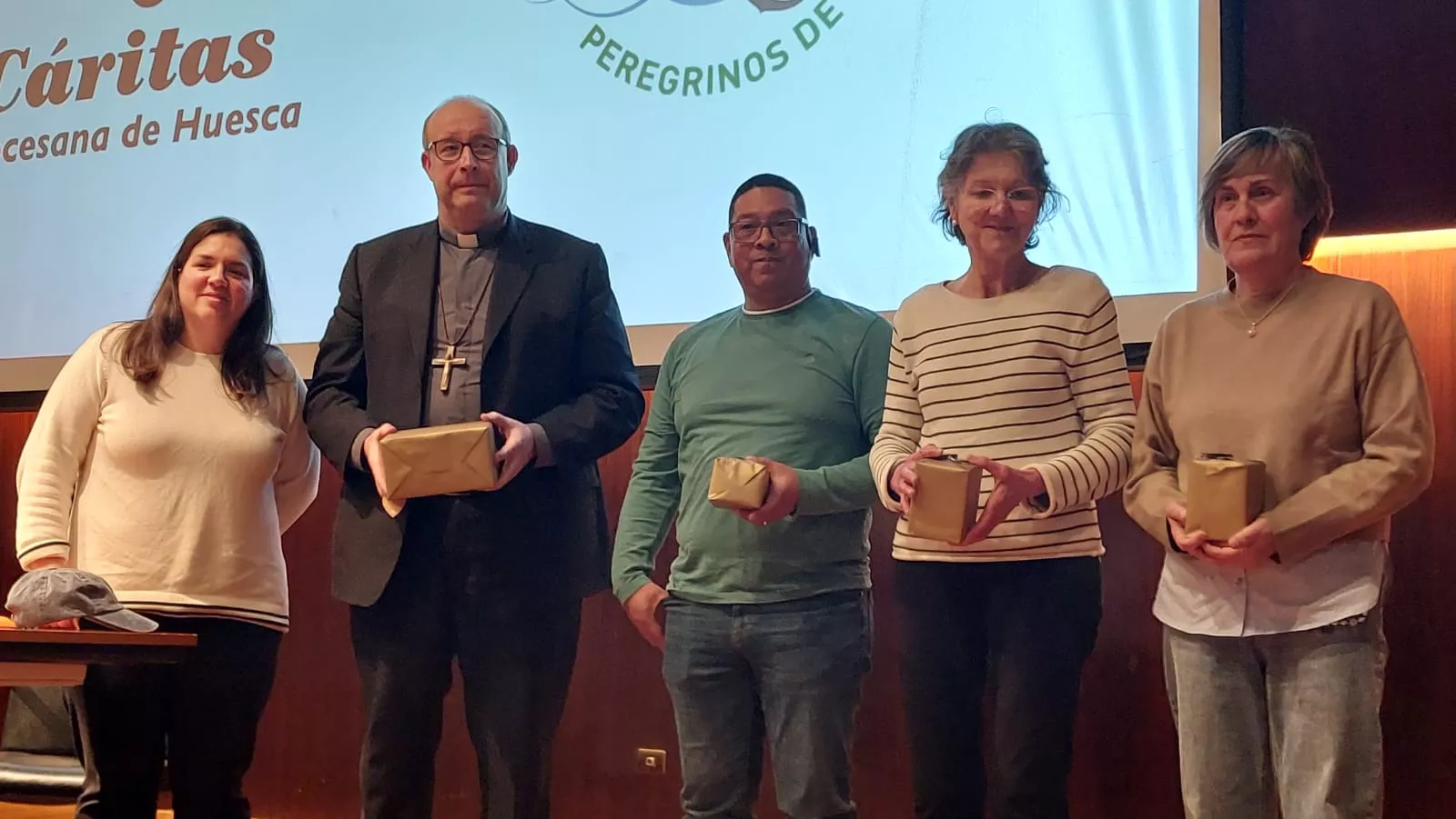 Isabel Ramos y José Antonio Satué, con los tres voluntarios en la apertura de las XVII Jornadas de Solidaridad de Cáritas
