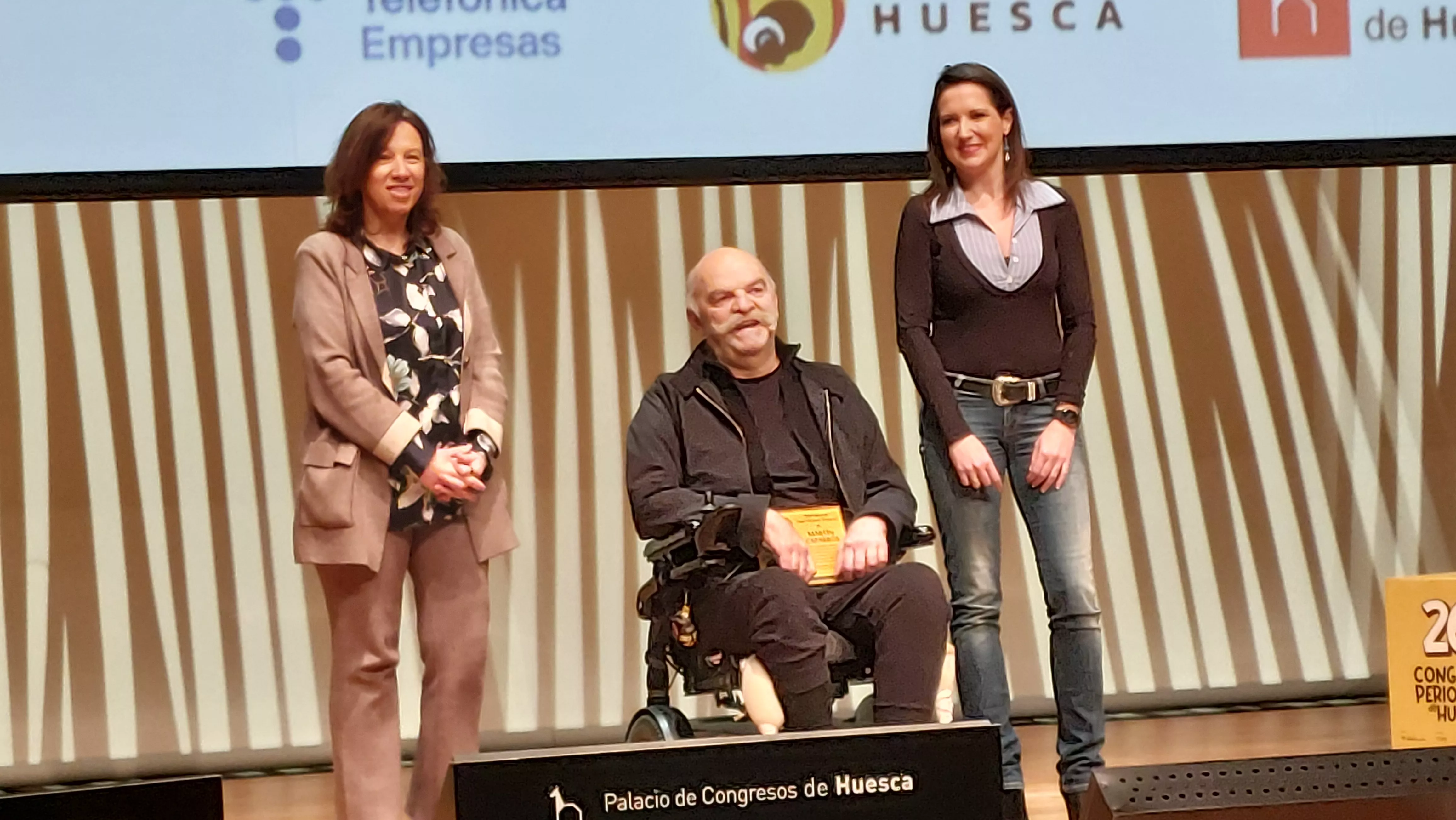 María Luisa Feijóo y Esther Aniento, con Martín Caparrós al recibir el Premio José Manuel Porquet