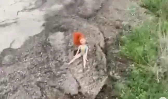 Muñeca sobre el asfalto