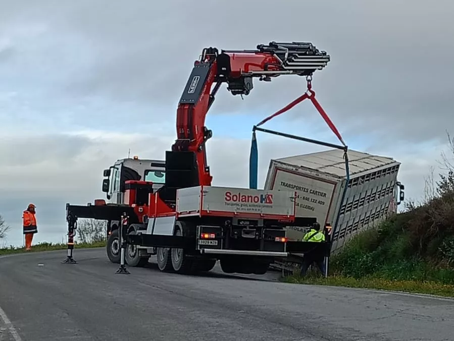 Una grúa retira el camión que se ha salido de la vía en la A-1223, en Peralta de Alcofea.