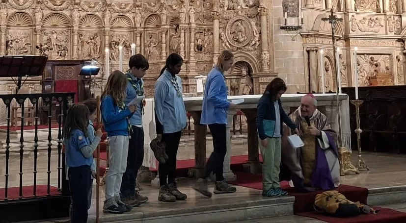 Como el buen pastor, agachado a la altura de sus feligreses, en este caso scouts