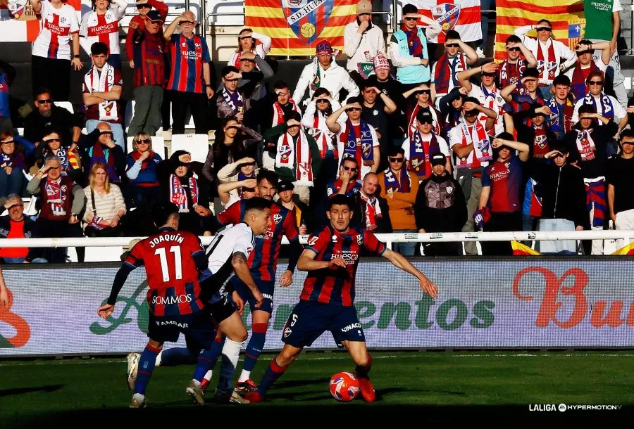 Loureiro y Joaquín, en una jugada en El Plantío, con la afición del Huesca de fondo. Foto: LaLiga
