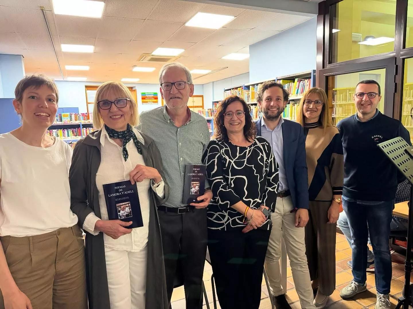 Presentación del libro "Poemas de Lamora y Adell" en Binéfar, con los autores que llevan el libro en la mano