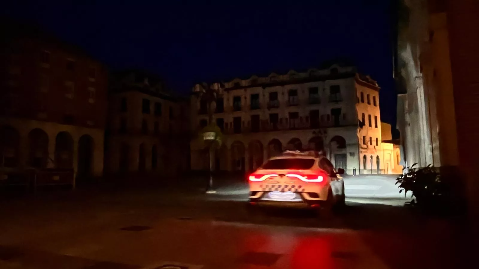 Un vehículo de la Policía Local de Huesca accede a la plaza López Allué que permanece sin alumbrado público. Foto Mercedes Manterola