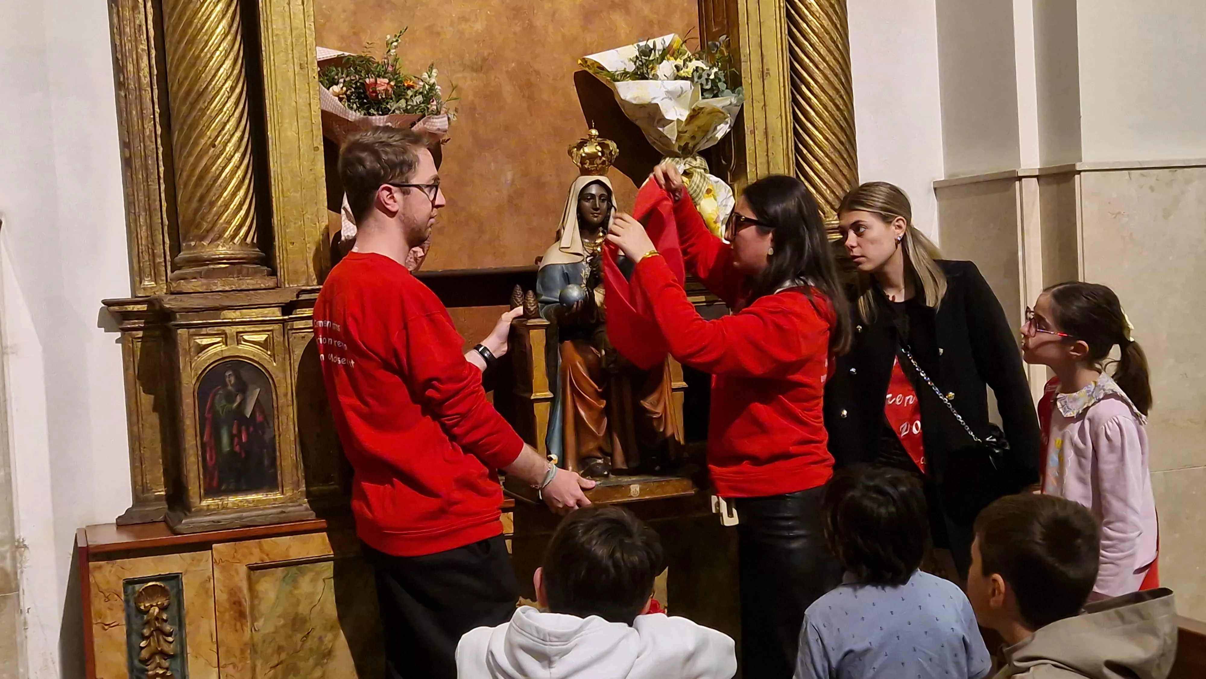Quitándole el pañuelo de las fiestas de San Lorenzo a la Virgen de Montserrat. Foto Myriam Martínez