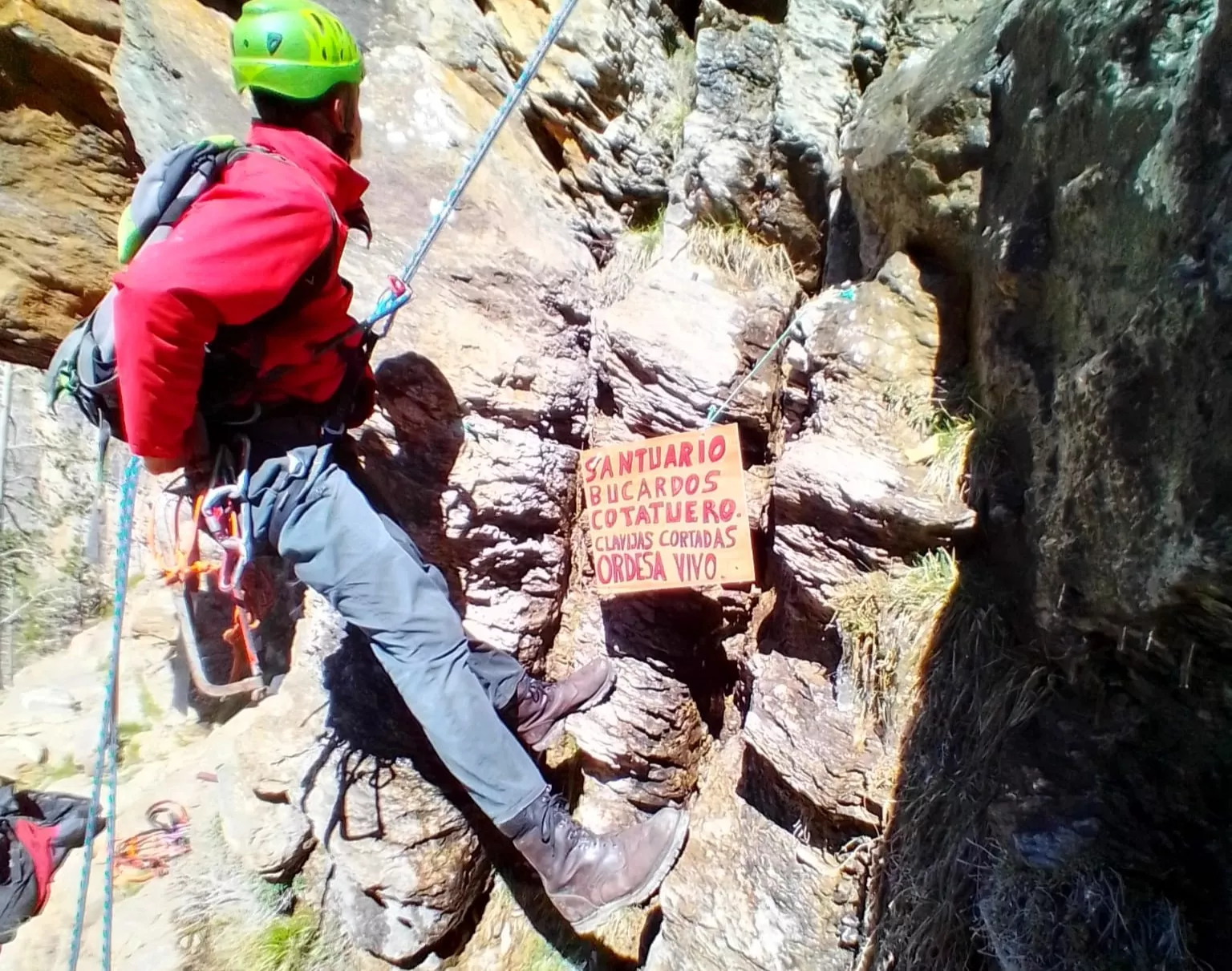 Un montañero colocando el cartel de avertencia