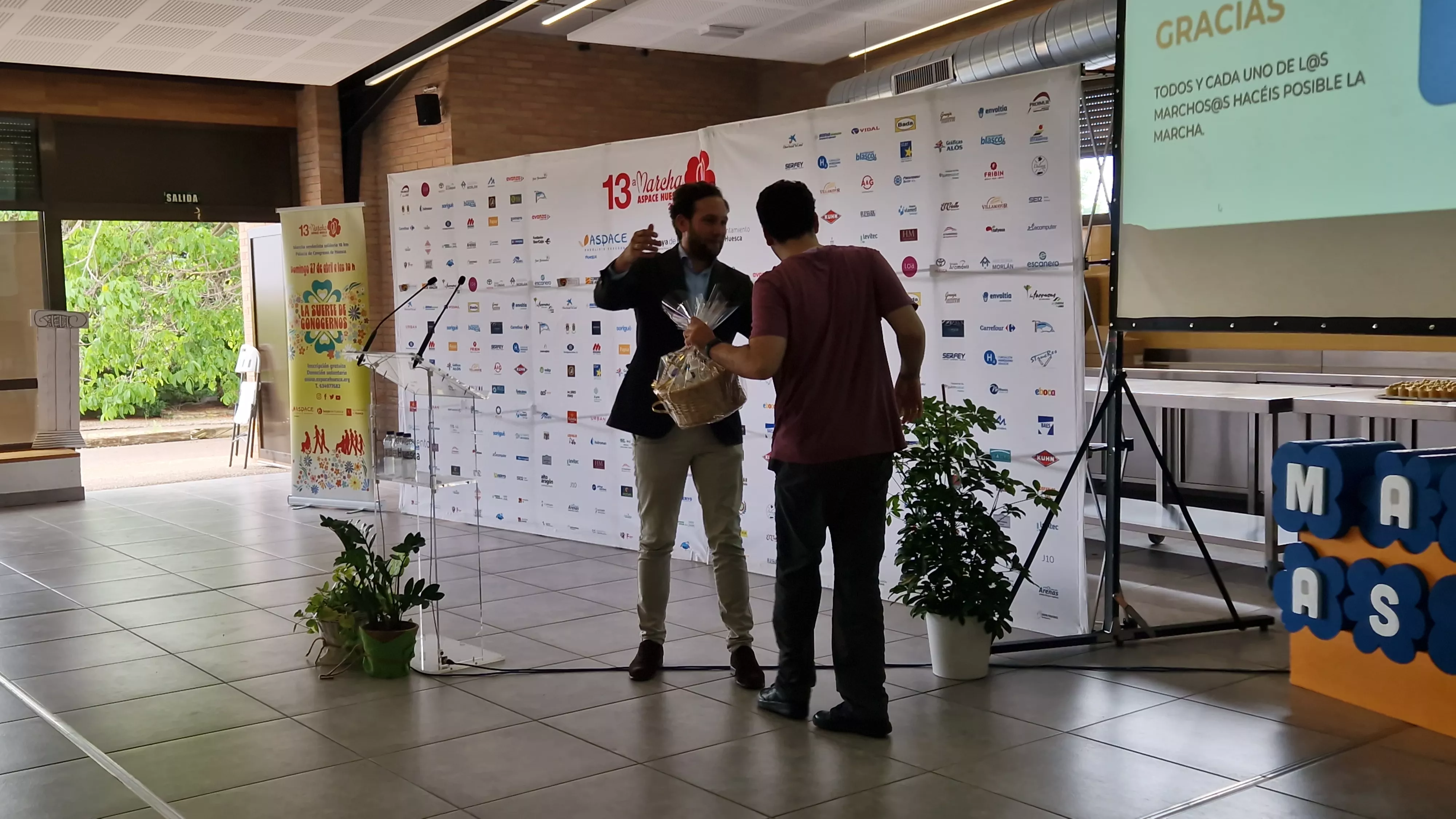 Claver recoge un regalo por el nacimiento de su hija que le da Javier en nombre de Aspace Huesca. Foto Myriam Martínez