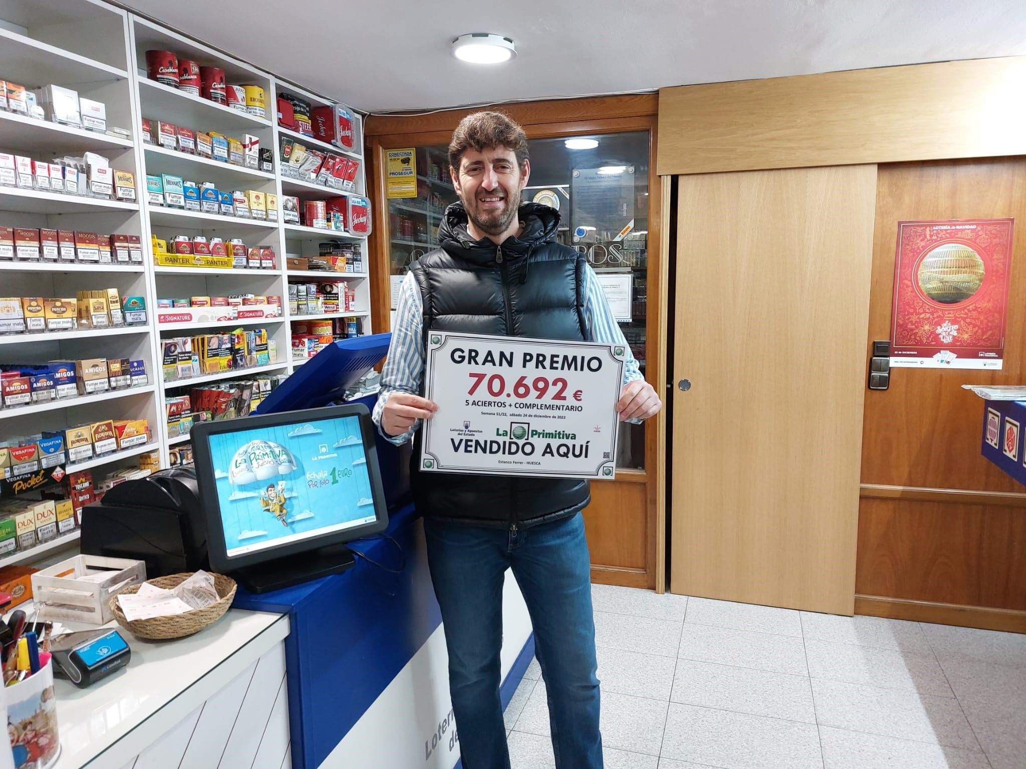 Pacho Ferrer con el cartel de Gran Premio en su estanco