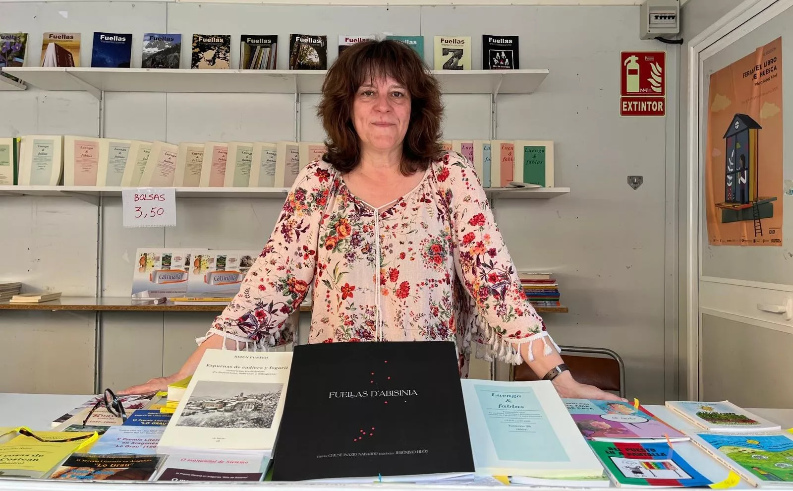 Ana Escar junto con las obras presentadas por el Consello d´a Fabla Aragonesa en la Feria del Libro de Huesca. Foto Mercedes Manterola