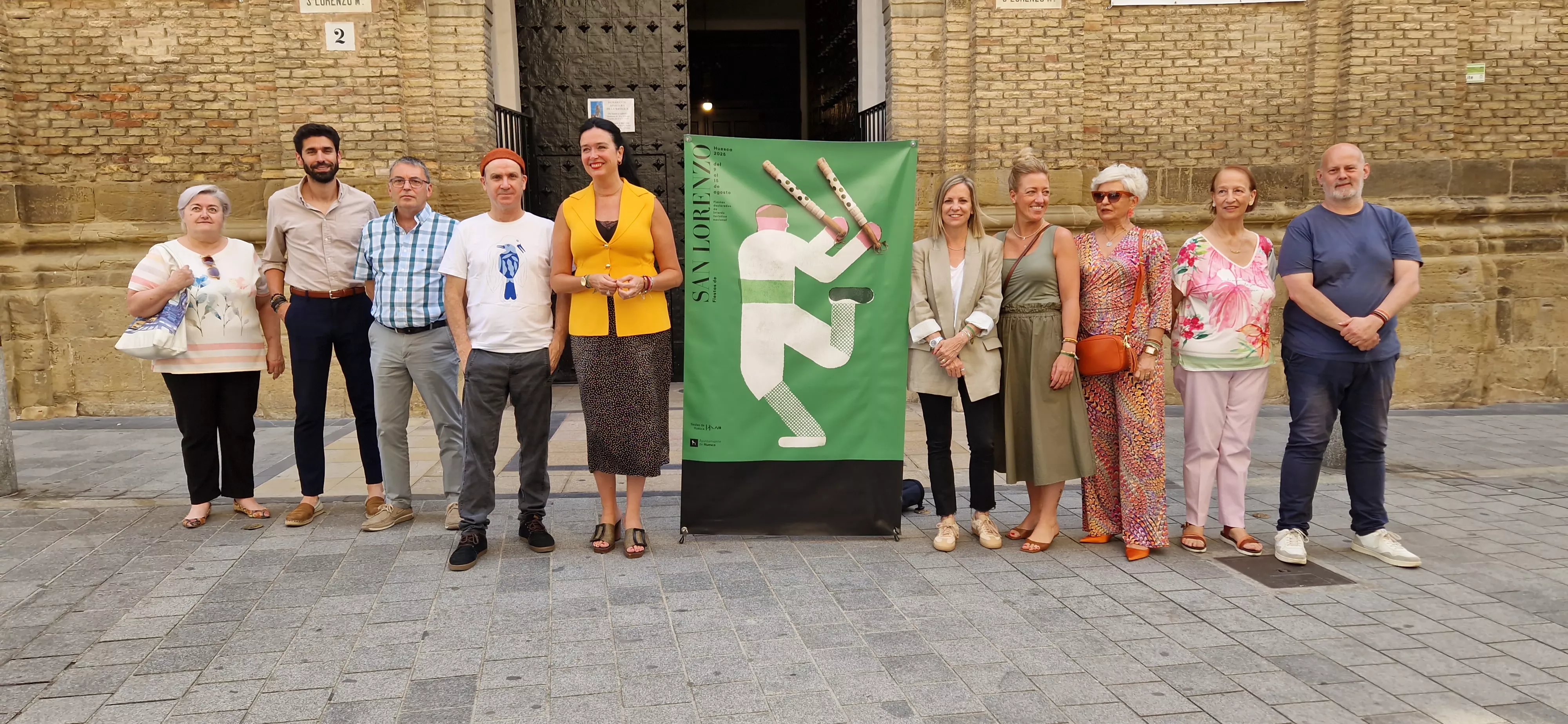 El cartel realizado por Isidro Ferrer, rodeado por el autor y diversos representantes de las fiestas de San Lorenzo. Foto Myriam Martínez