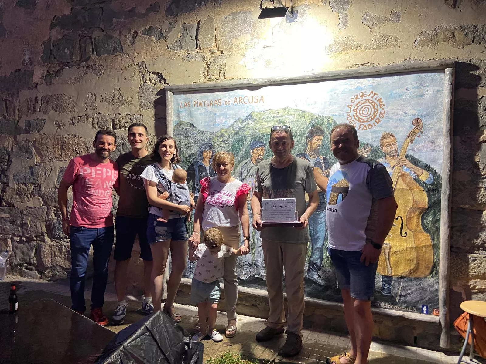 Luis Moreno con la placa conmemorativa junto al presidente de los vecinos David Broto familiares y el alcalde Enrique Pueyo.