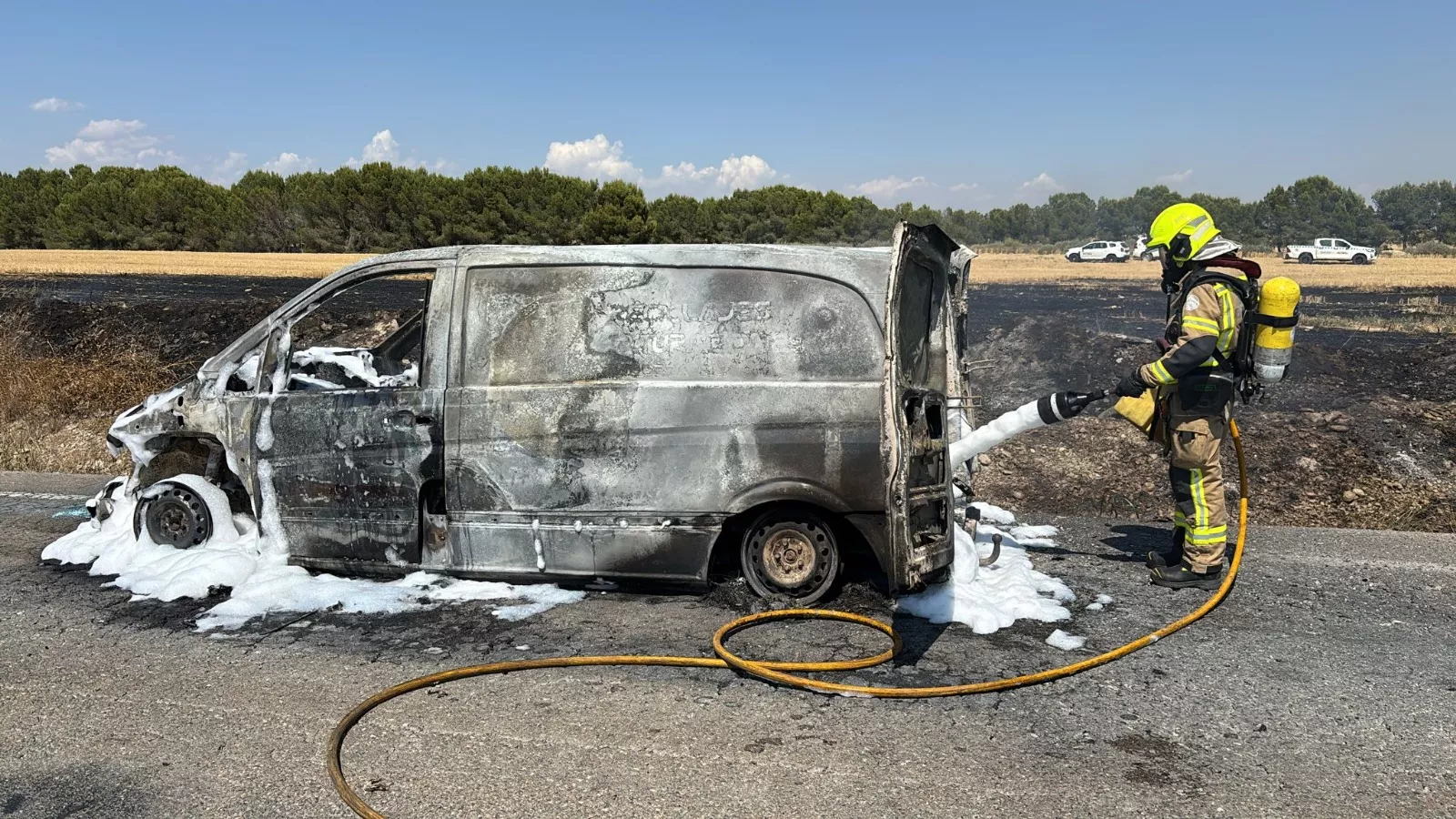 Una furgoneta arde en Tardienta y provoca un incendio en un campo junto a la carretera.