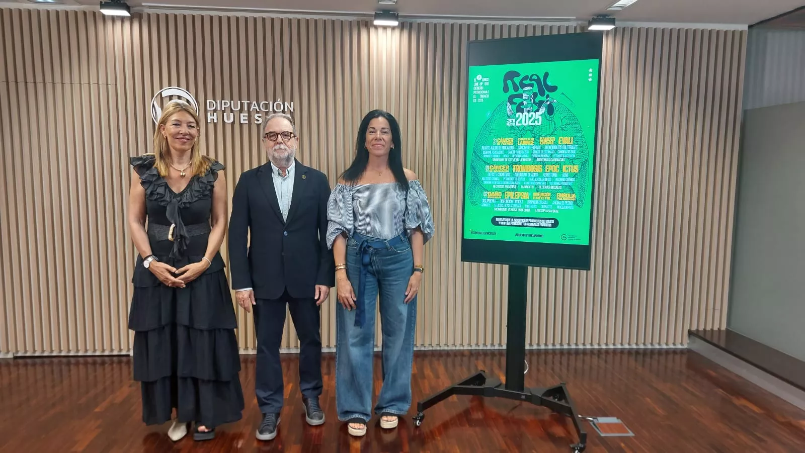 Marta Escartín, José Manujel Ramón y Cajal y Lola Ibort con el cartel del Real Fest 2025