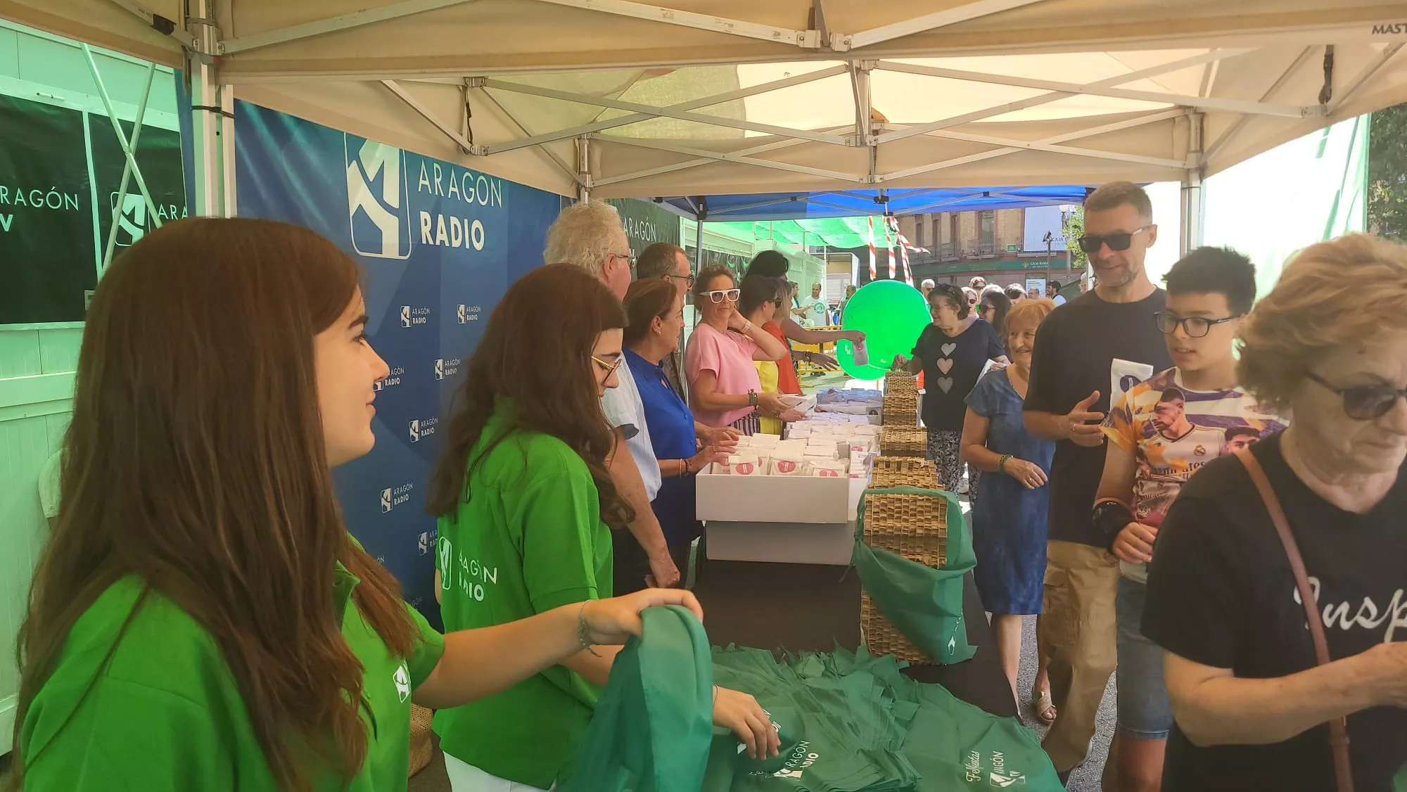 Reparto de panes de San Lorenzo y pañoletas de Aragón Radio y Aragón TV