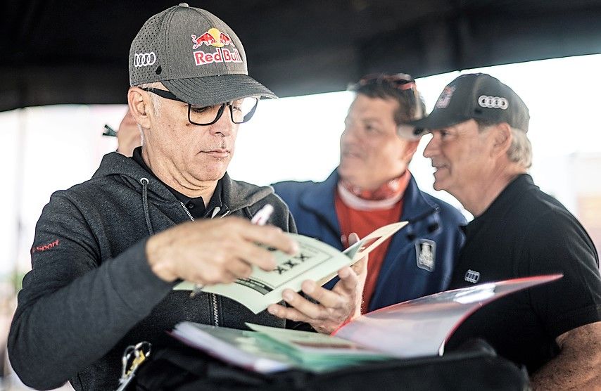 Carlos Sainz, al fondo, conversa con el barbastrense César Abraldes.