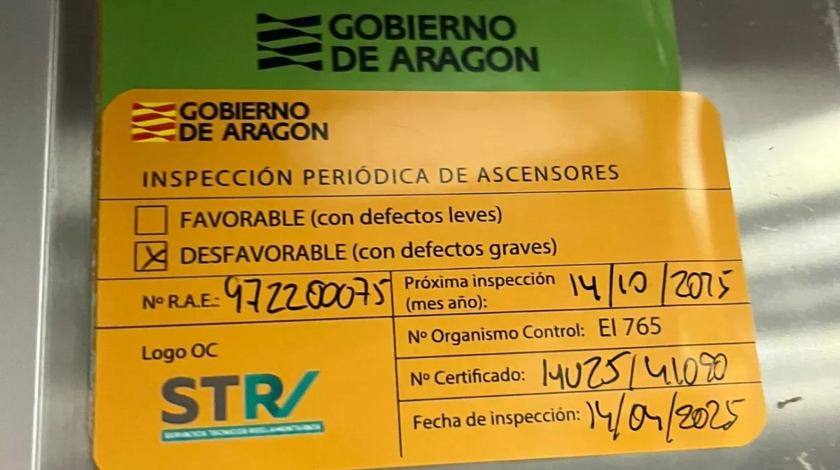 Pegatina oficial del Gobierno de Aragón que refleja que la inspección es "desfavorable". Ciudadanos denuncian los "defectos graves" en los ascensores del Hospital San Jorge de Huesca